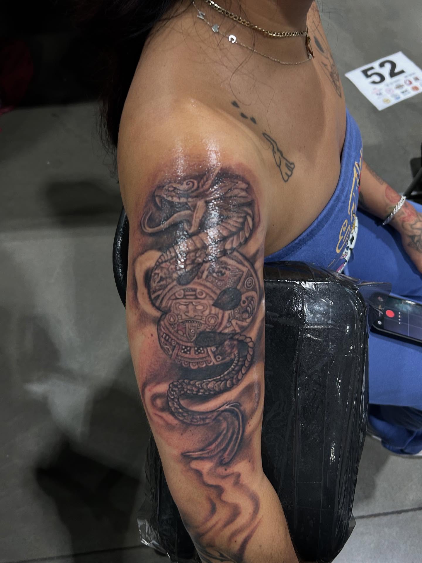 Serpent realism tattoo on the upper arm by Cyko Hernandez