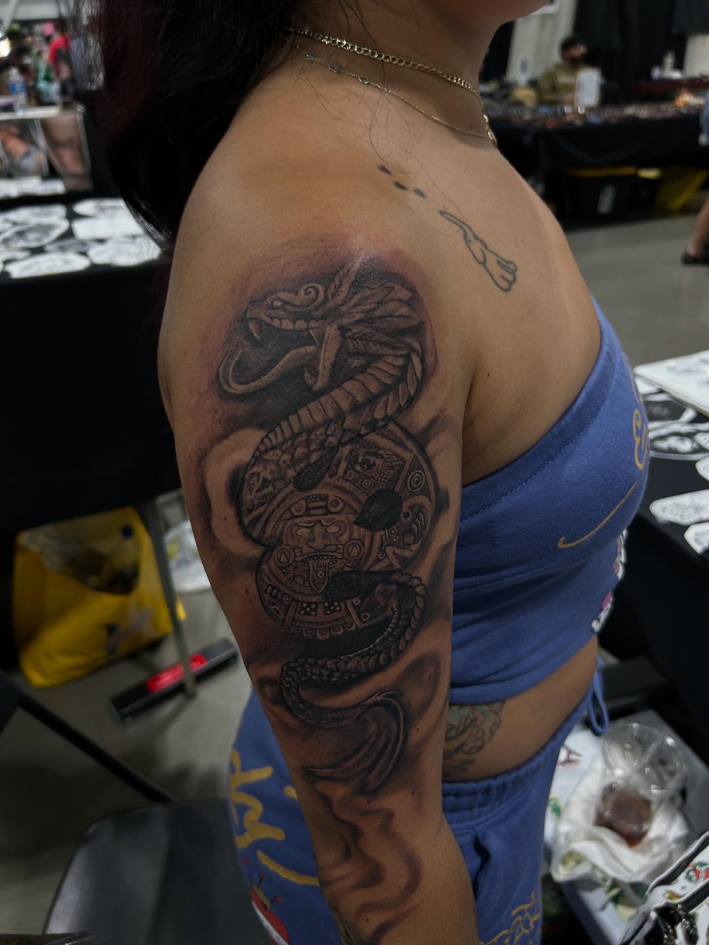 Serpent and calendar realism tattoo on the shoulder by Cyko Hernandez