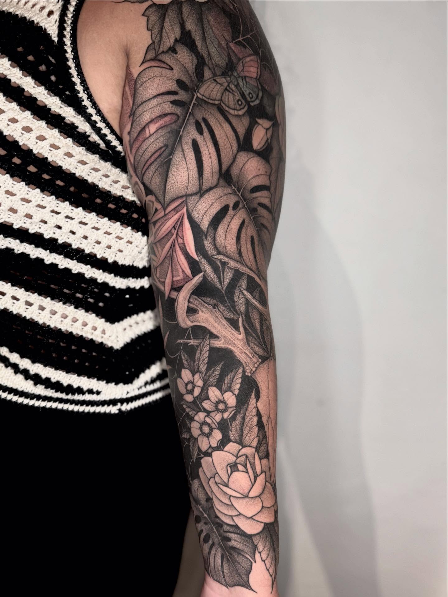 Monstera leaves and rose realism tattoo on the forearm by Lauren Llerandi