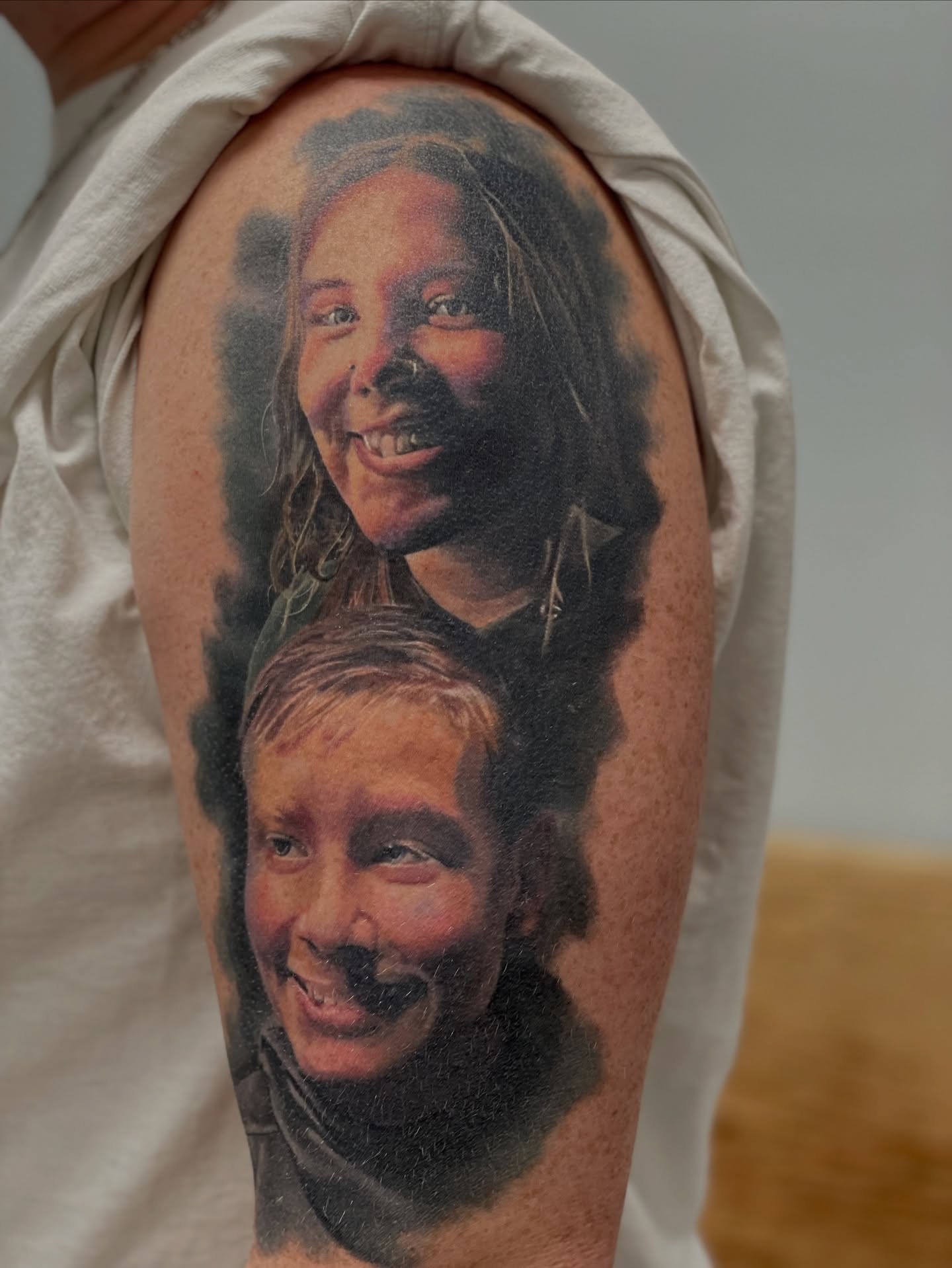 Portrait realism tattoo on the upper arm by Justin Shelpman
