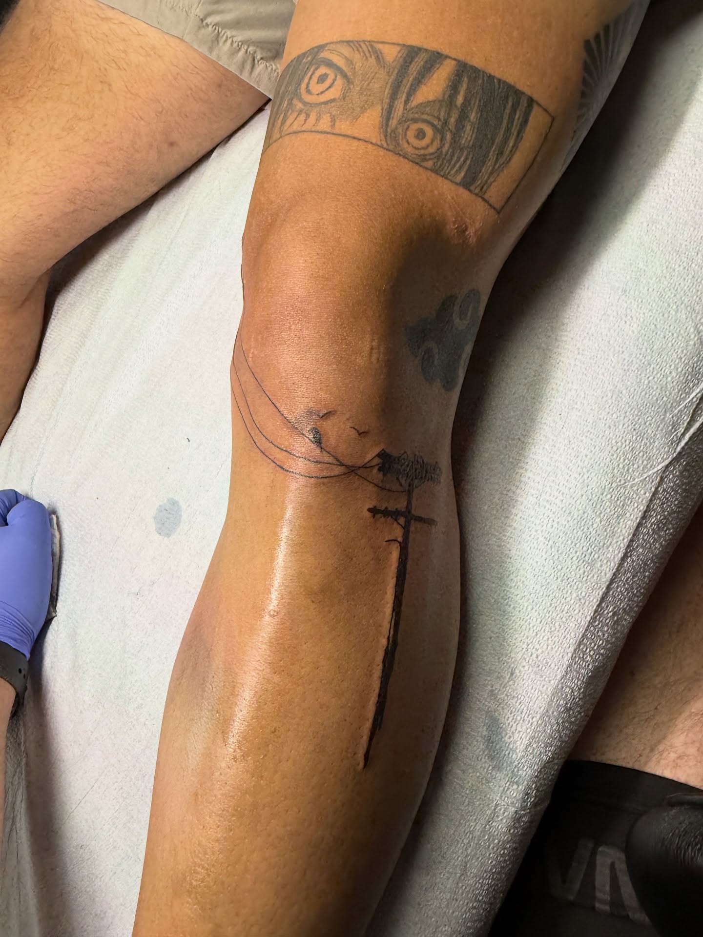 Telephone pole and birds black and grey tattoo on the forearm by Ben McKee