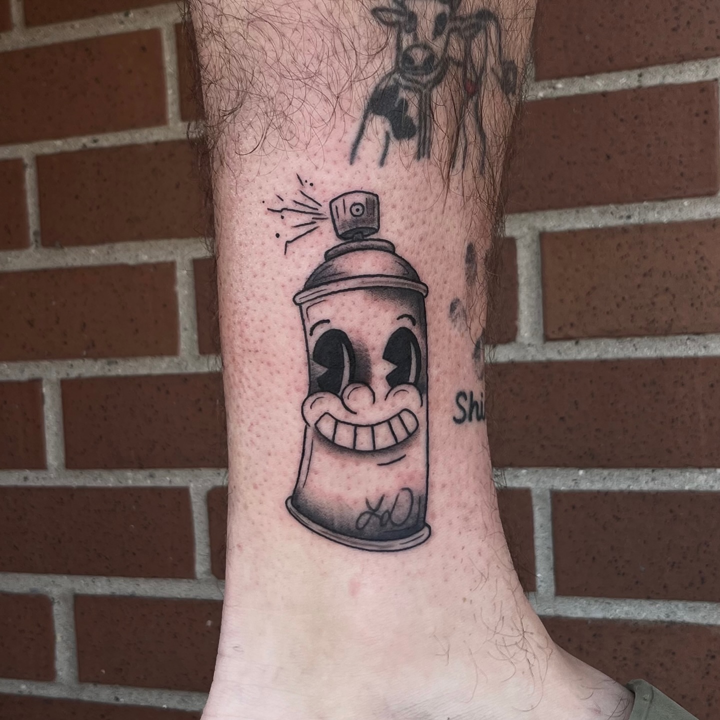 Spray can black and grey tattoo on the forearm by Lauren Dempsey, Dearborn, Michigan