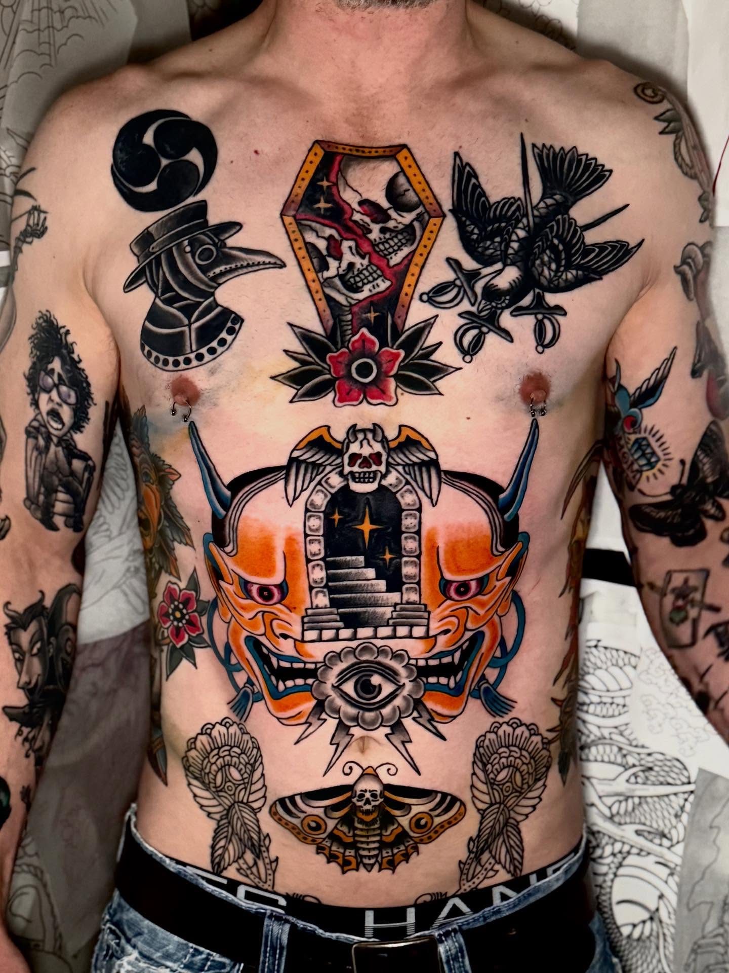 Japanese mask American traditional tattoo on the chest by Seth Walker
