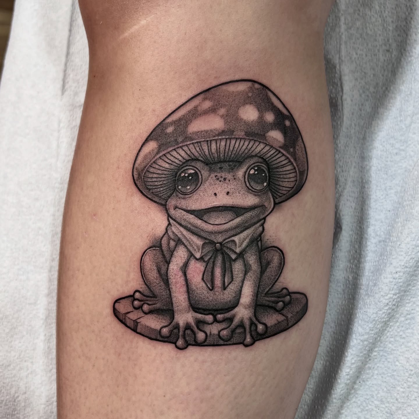 Frog with mushroom hat dotwork tattoo on the forearm by Kendall Orlando