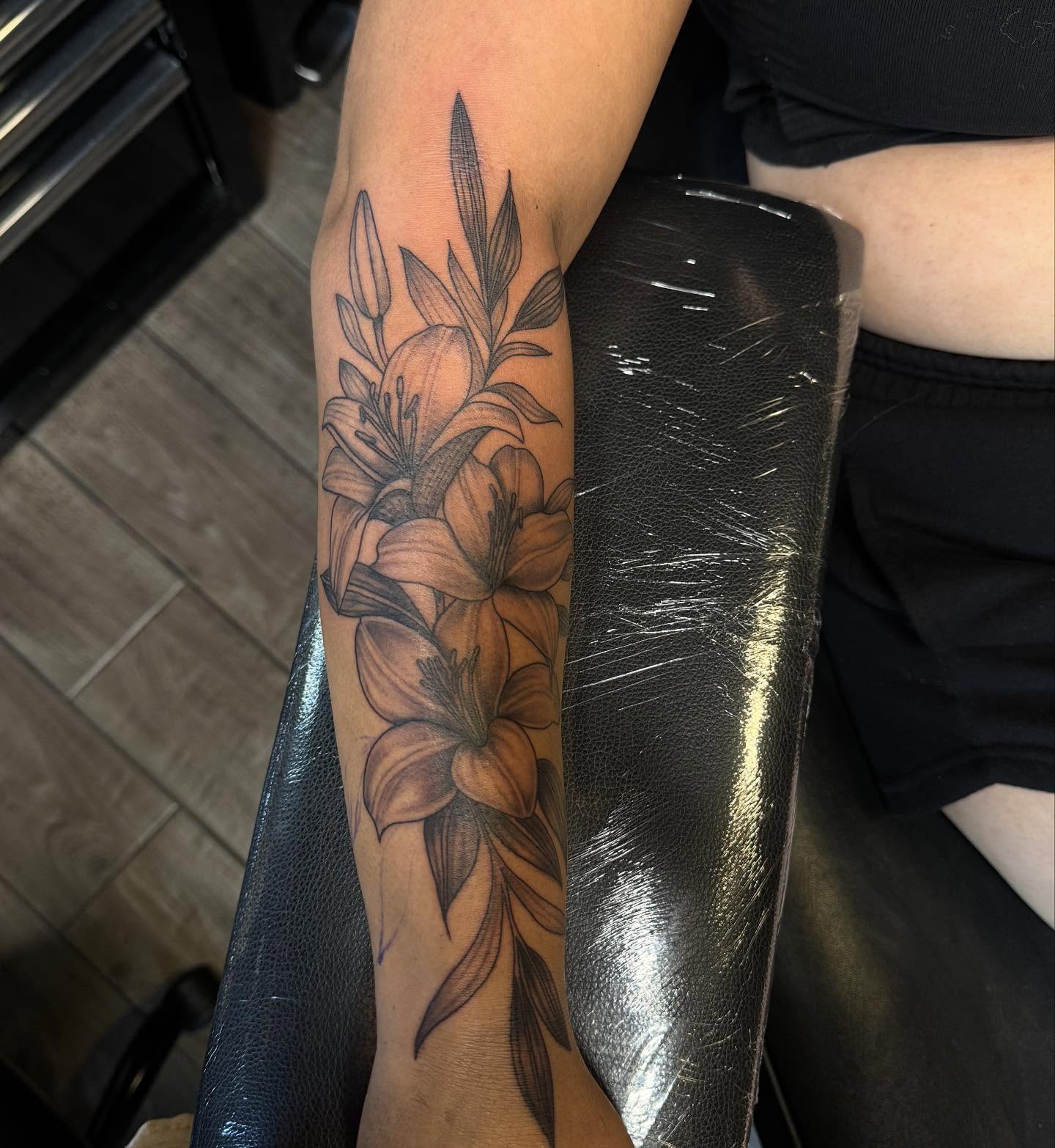 Lilies black and grey tattoo on the forearm by Mickey