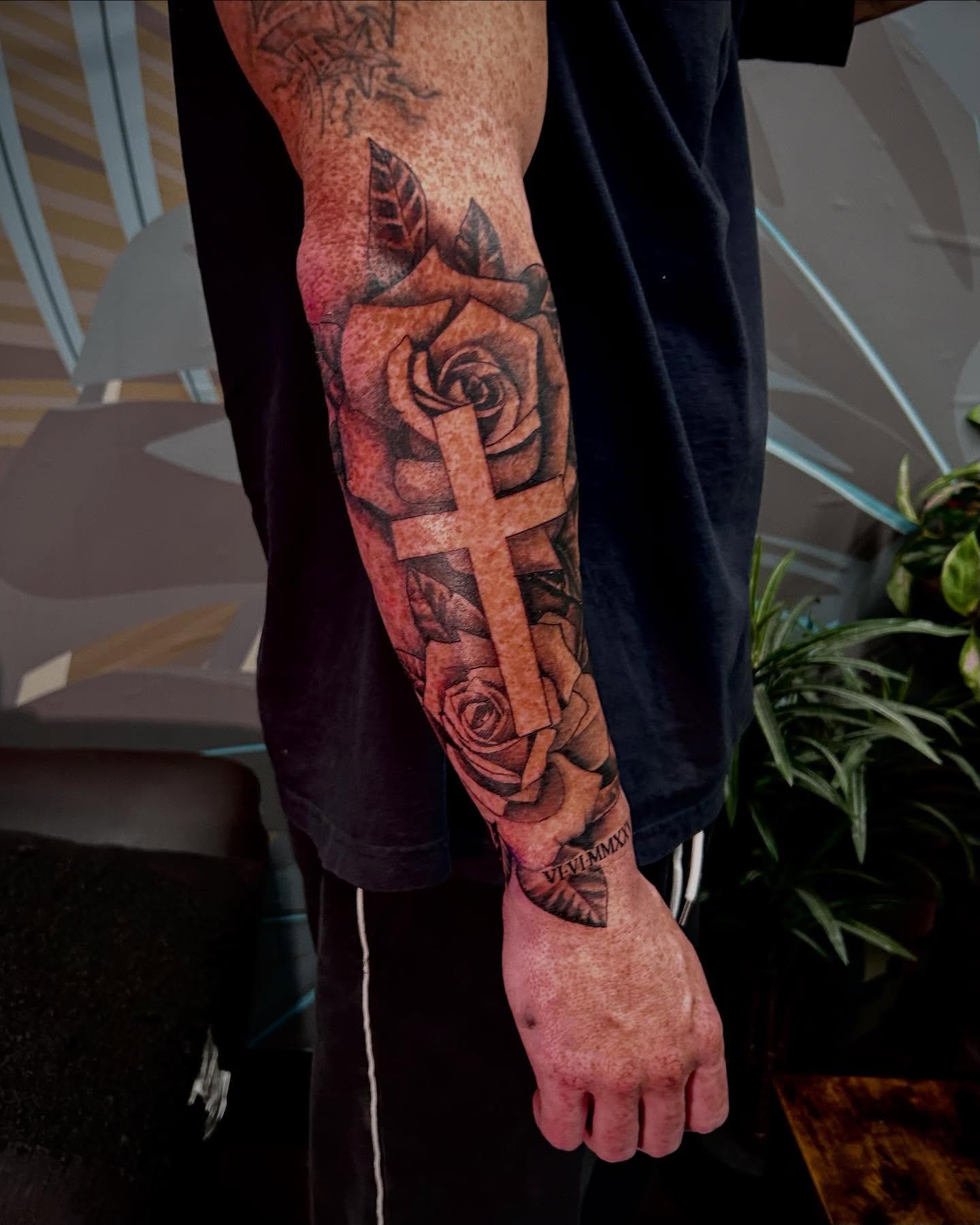 Roses and cross realism tattoo on the forearm by Jon Byrd