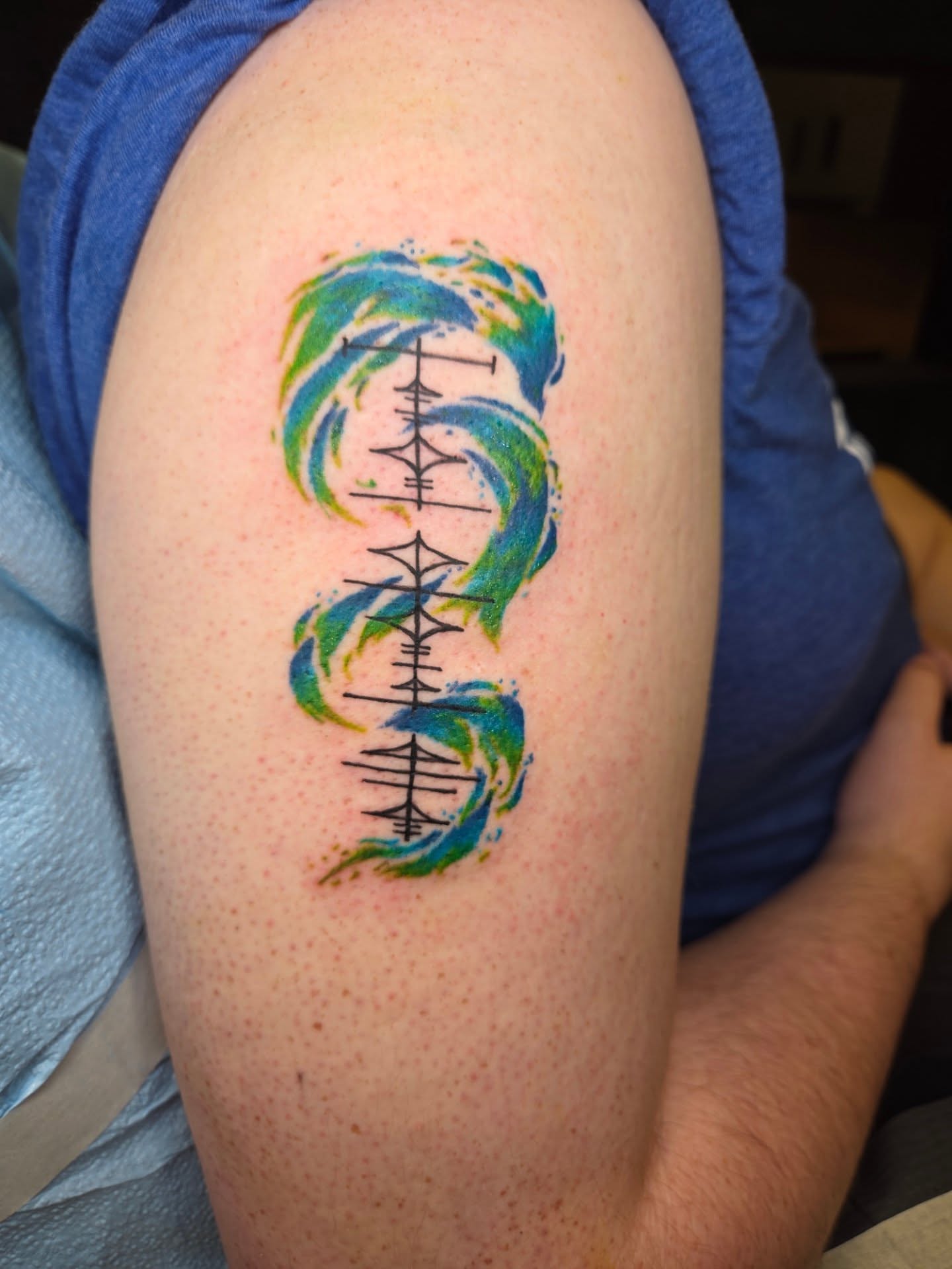 Infinity symbol with watercolor swirls watercolor tattoo on the shoulder by Chaz Escobar
