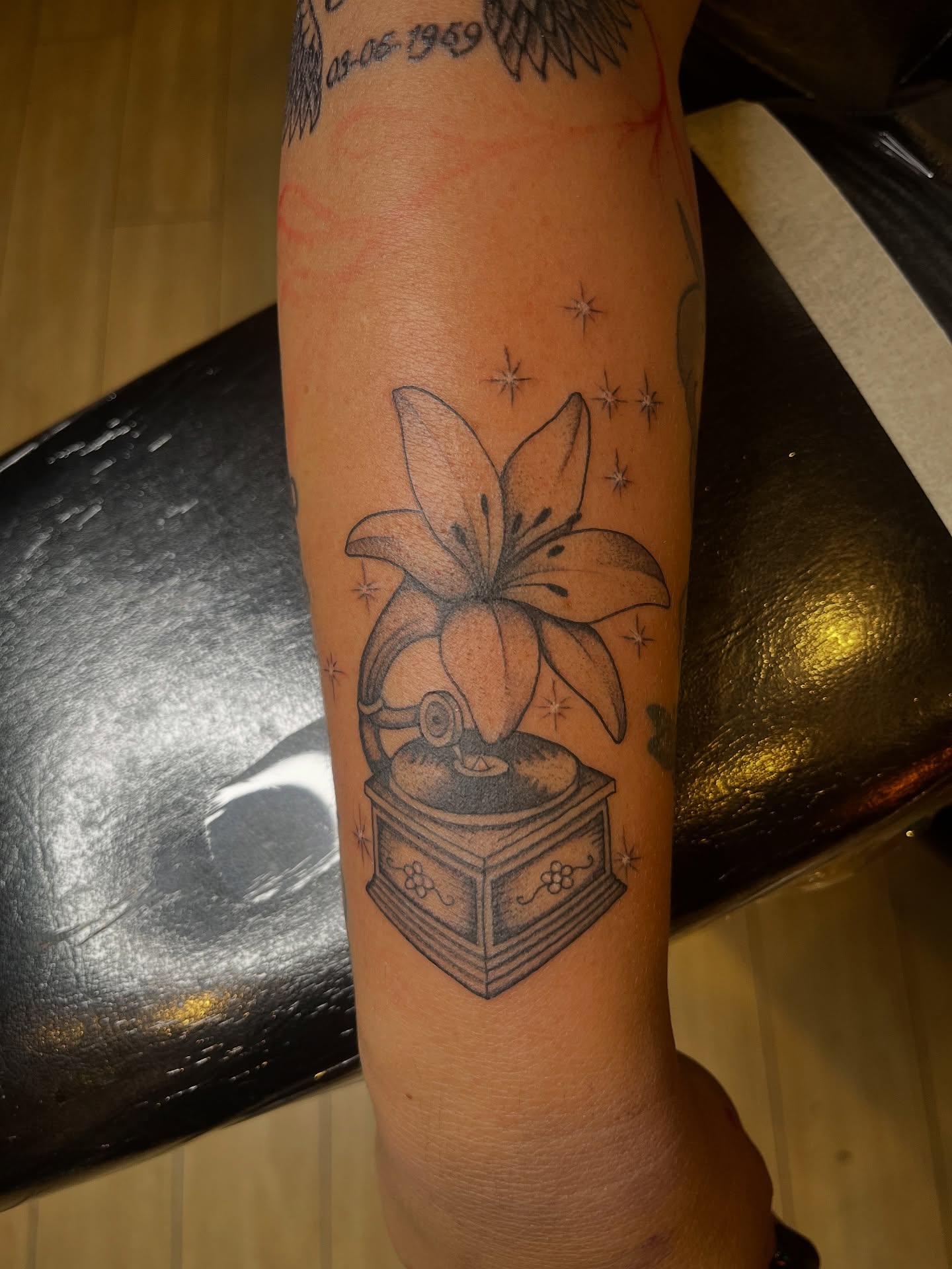 Lily and gramophone black and grey tattoo on the forearm by Winston Thai