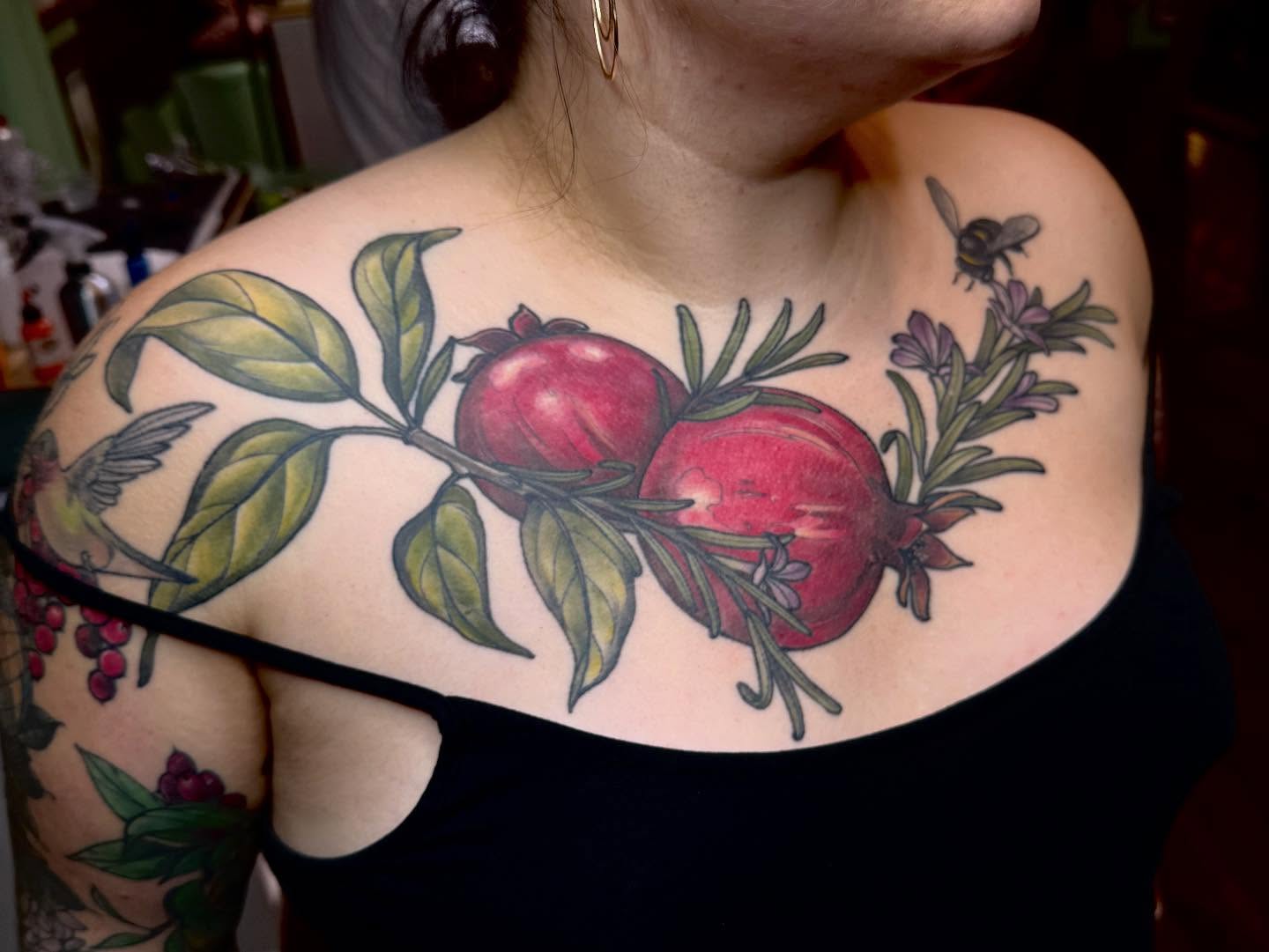 Pomegranates and flowers realism tattoo on the shoulder by Rachael Shelly