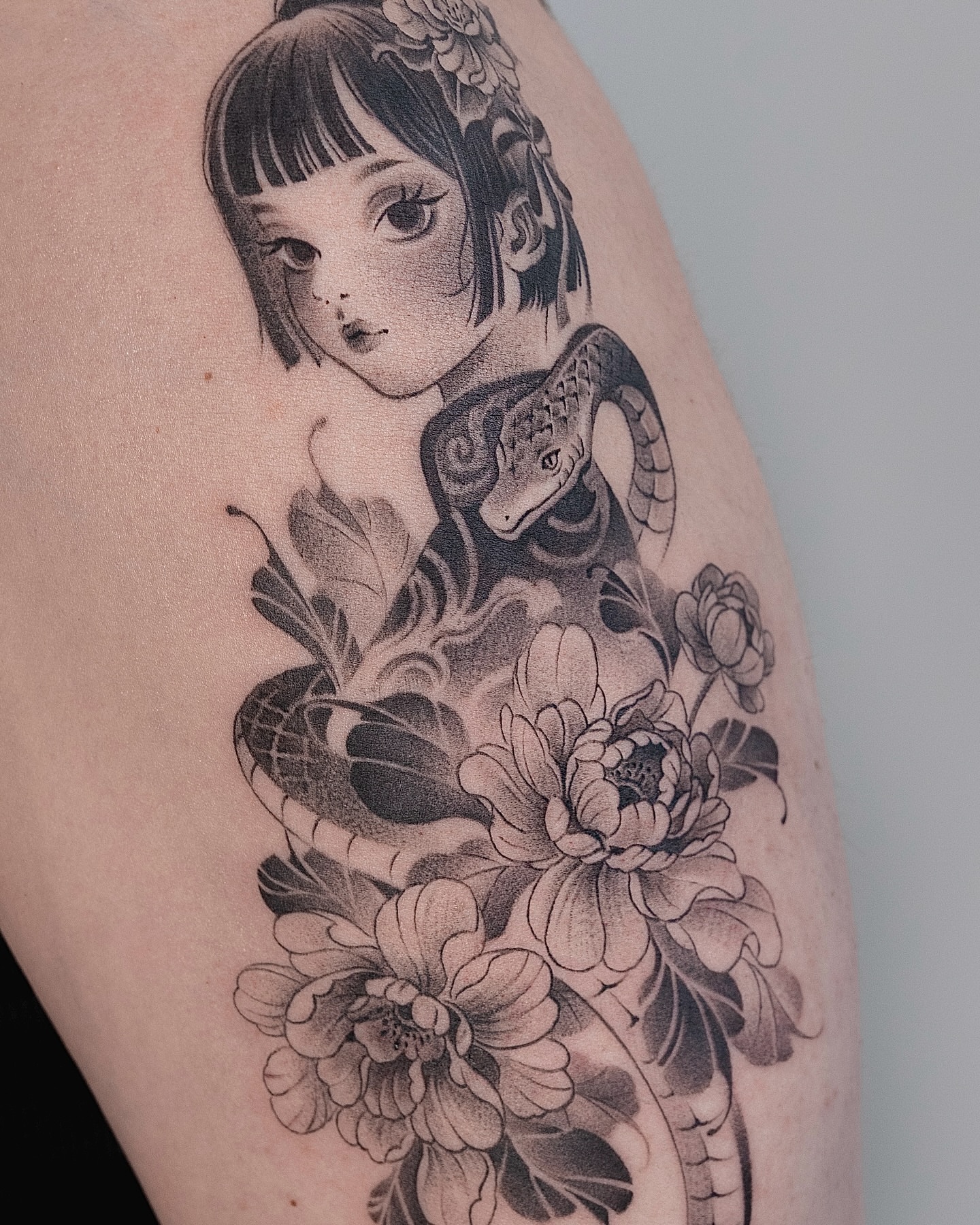 Snake and peony realism tattoo on the upper arm by 라이브 Live