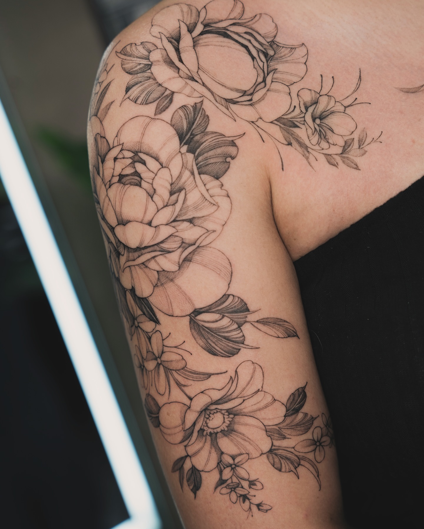 Floral bouquet realism tattoo on the upper arm by Tri