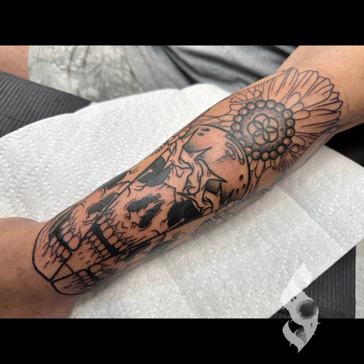 Sunflower and skull black and grey tattoo on the forearm by Amanda Stampfly