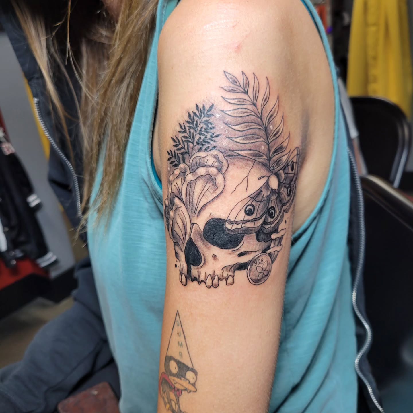 Skull and floral realism tattoo on the shoulder by Aspen C