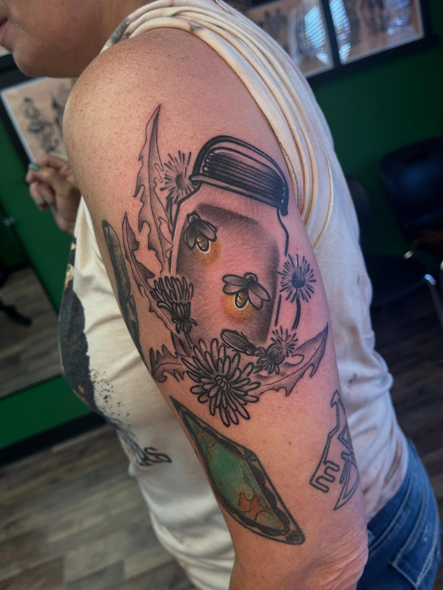 Flower wreath with bee black and grey tattoo on the upper arm by Josh Roberts, Franklin, Ohio