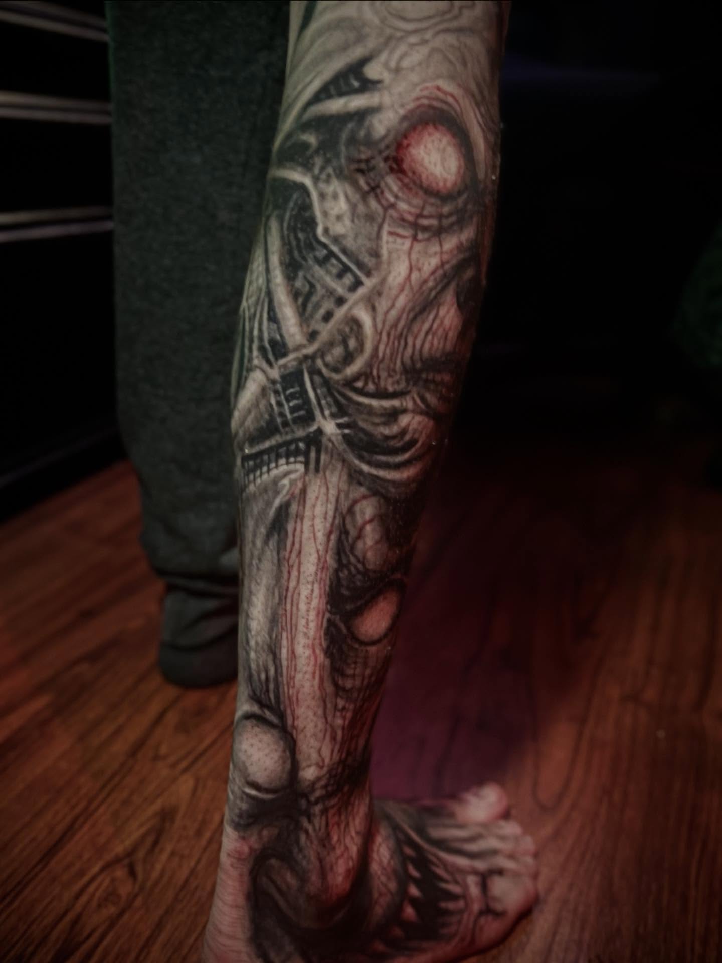 Cityscape dark realism tattoo on the forearm by Paul Booth