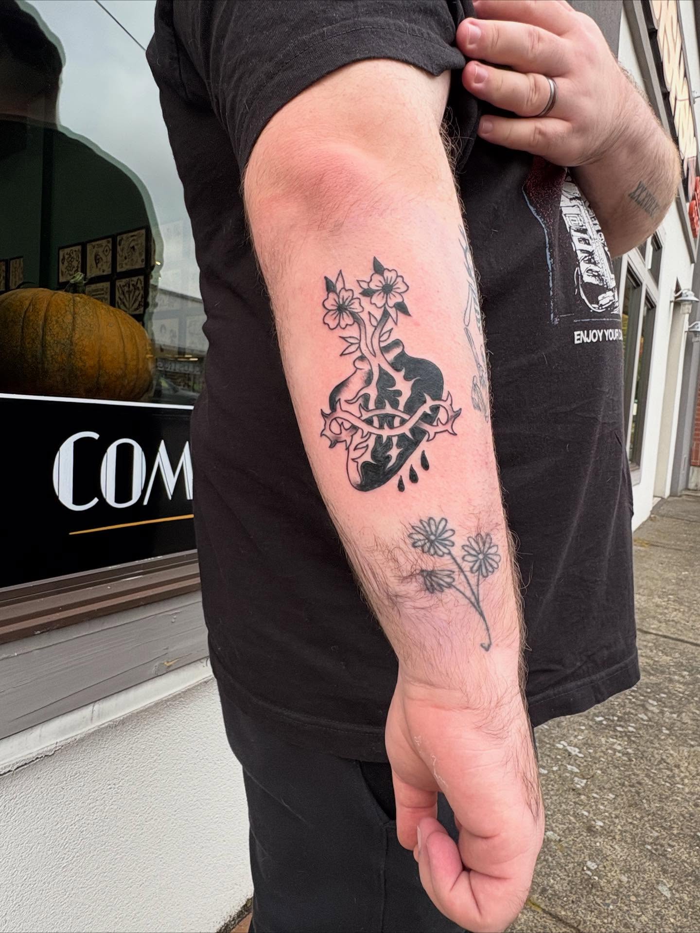 Heart with flowers black and grey tattoo on the forearm by ellie