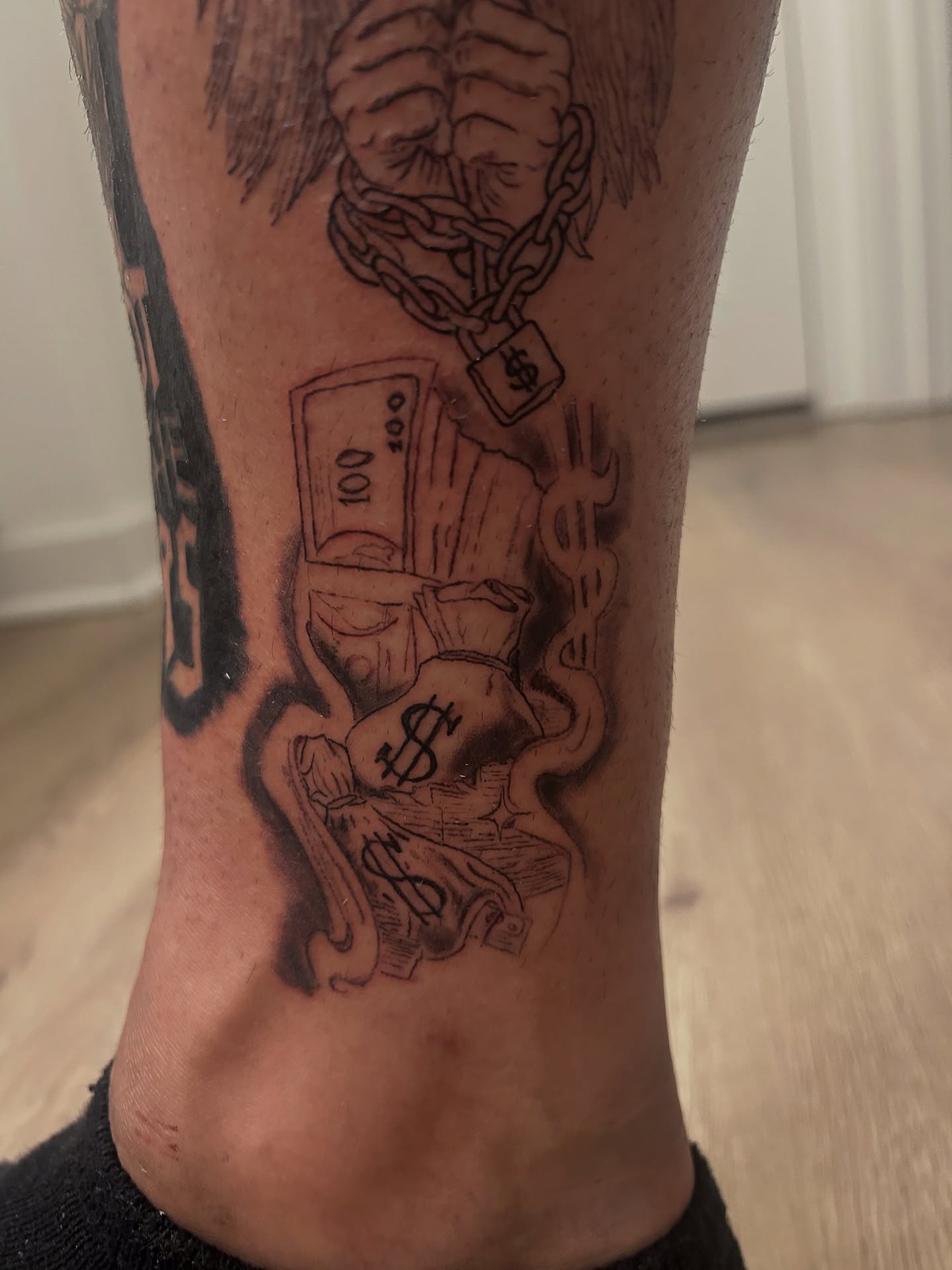 Money and chains black and grey tattoo on the calf by Trae