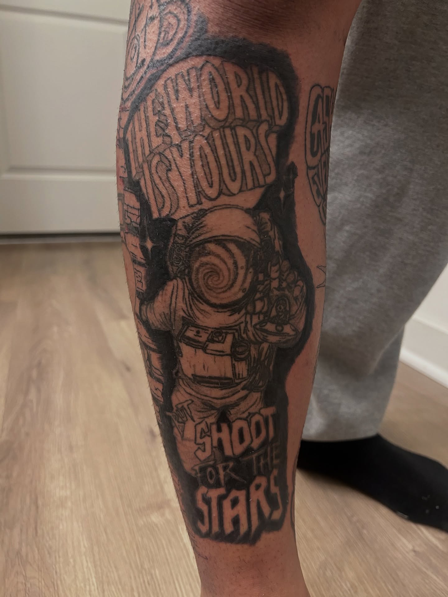 Astronaut with motivational quote black and grey tattoo on the forearm by Trae
