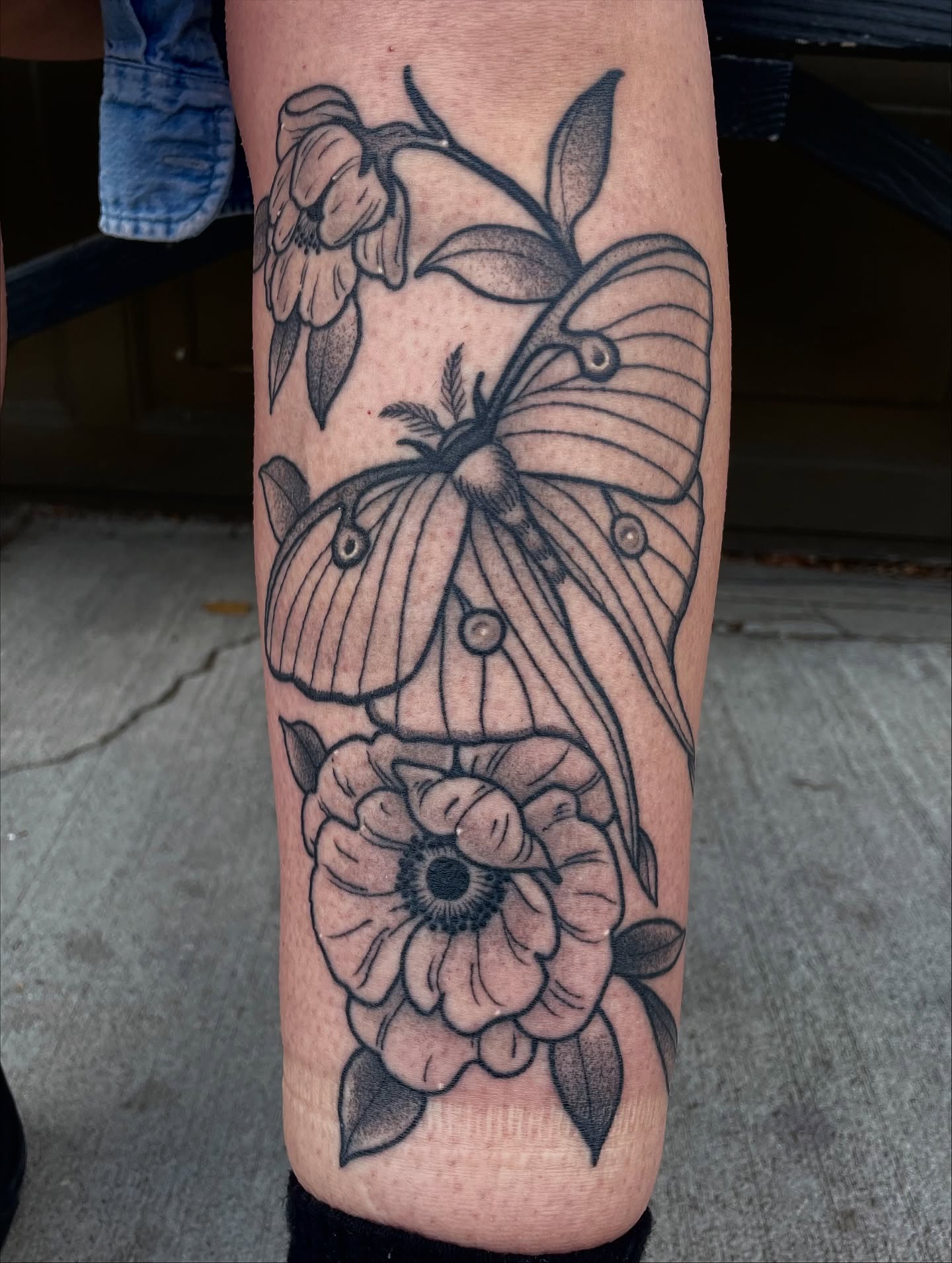 Butterfly and flowers black and grey tattoo on the forearm by Emily Lux