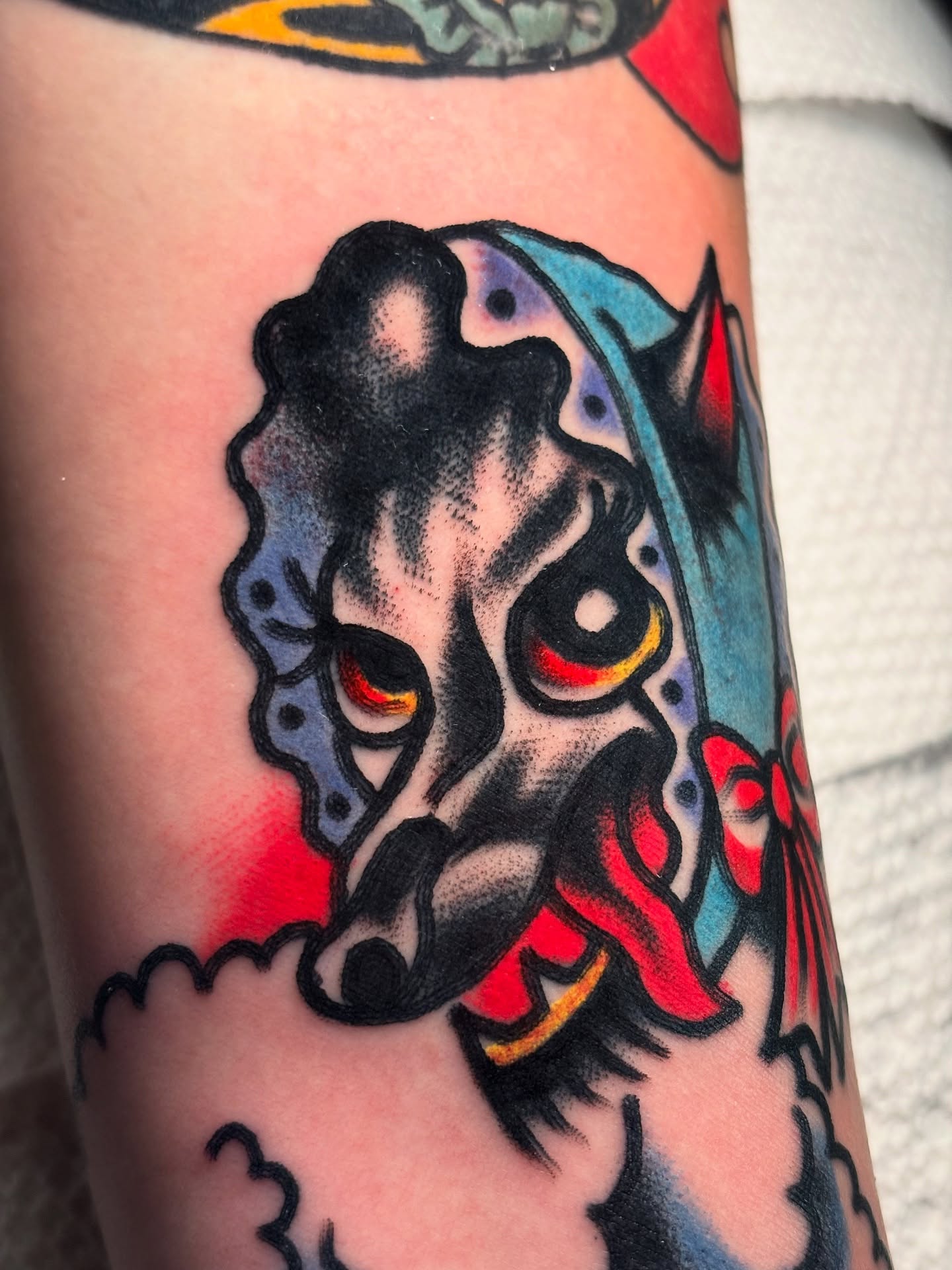 Mask American traditional tattoo on the forearm by Nick