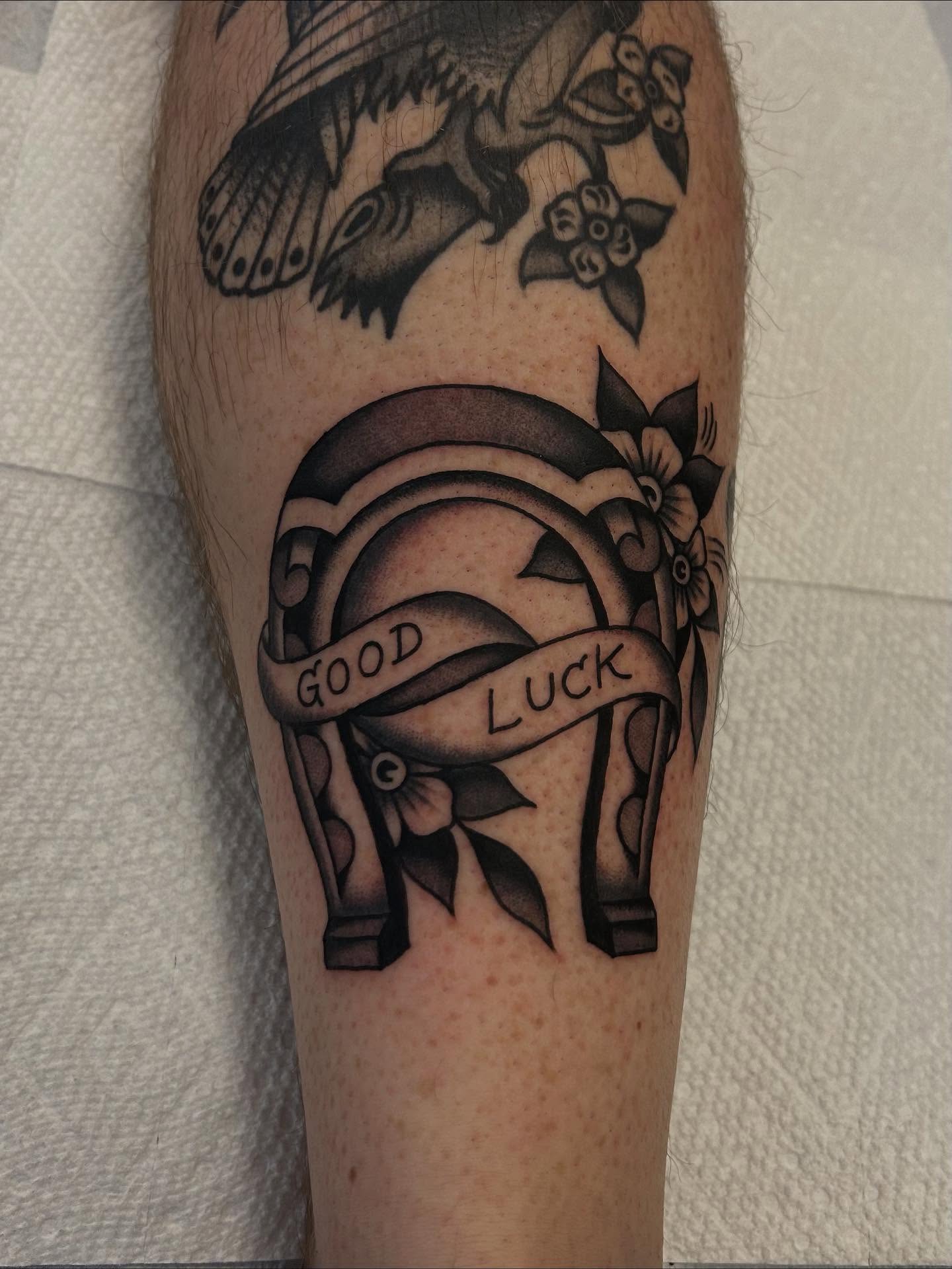 Horseshoe and ribbon American traditional tattoo on the forearm by Christian Lasyone