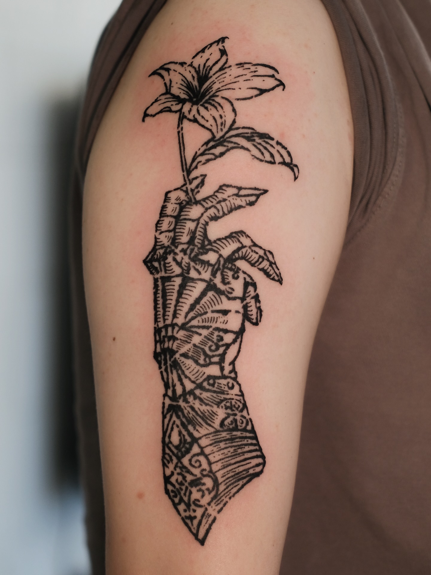 Lily and dagger black and grey tattoo on the shoulder by ꜰʟᴏʀᴀ ᴡᴏᴏᴅᴄᴜᴛ ᴛᴀᴛᴛᴏᴏ