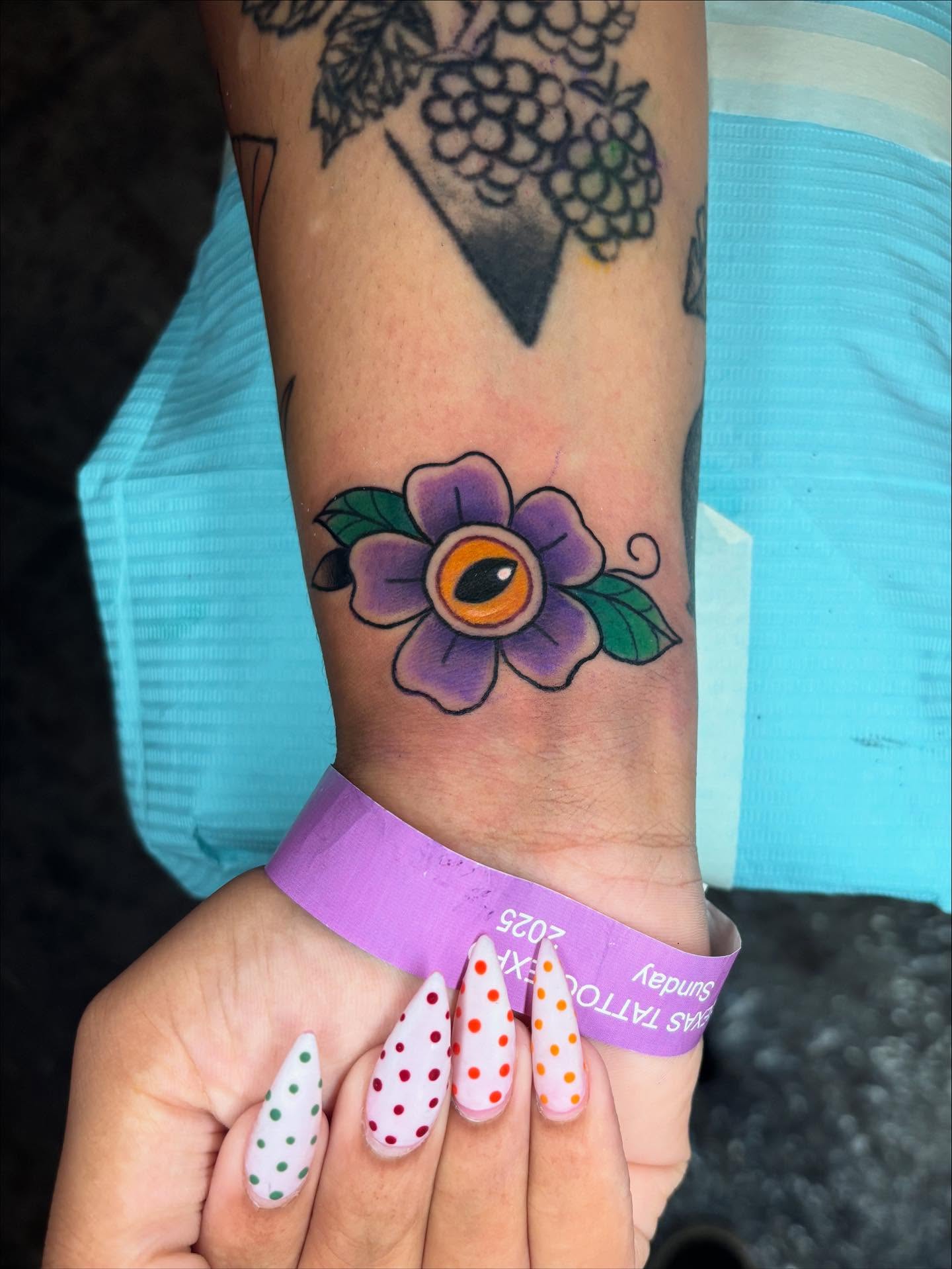 Purple flower with eye dotwork tattoo on the forearm by Chelsey Moore, Albuquerque, New Mexico