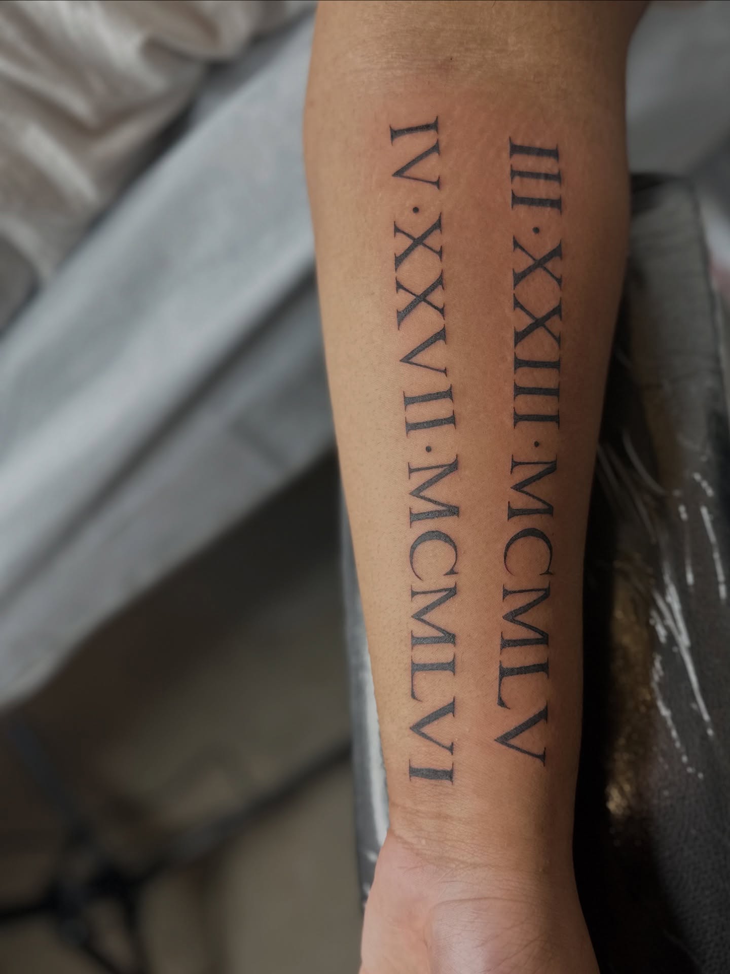 Roman numerals lettering script tattoo on the forearm by Cherry🥀