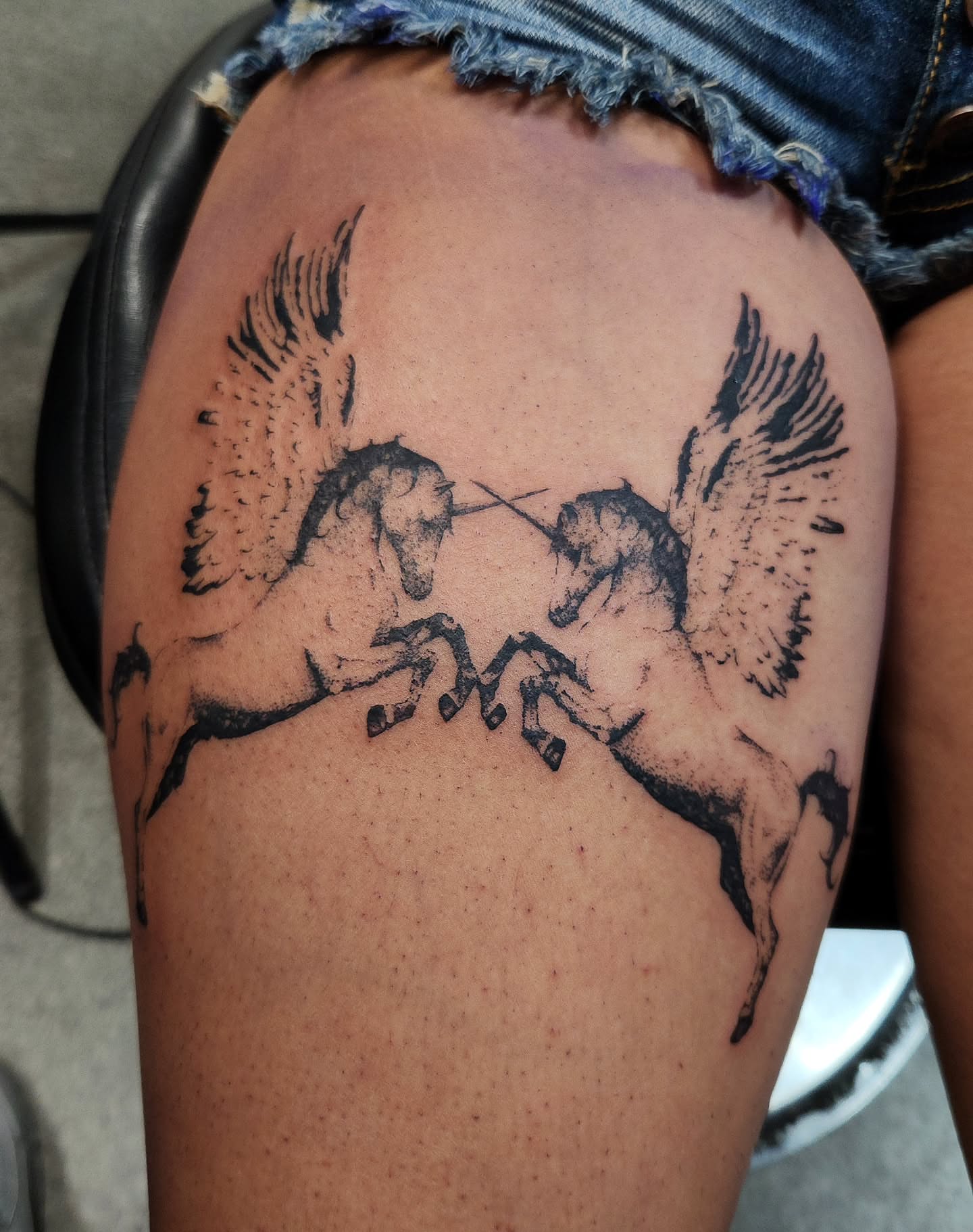 Unicorns black and grey tattoo on the thigh by Adrian Chavez