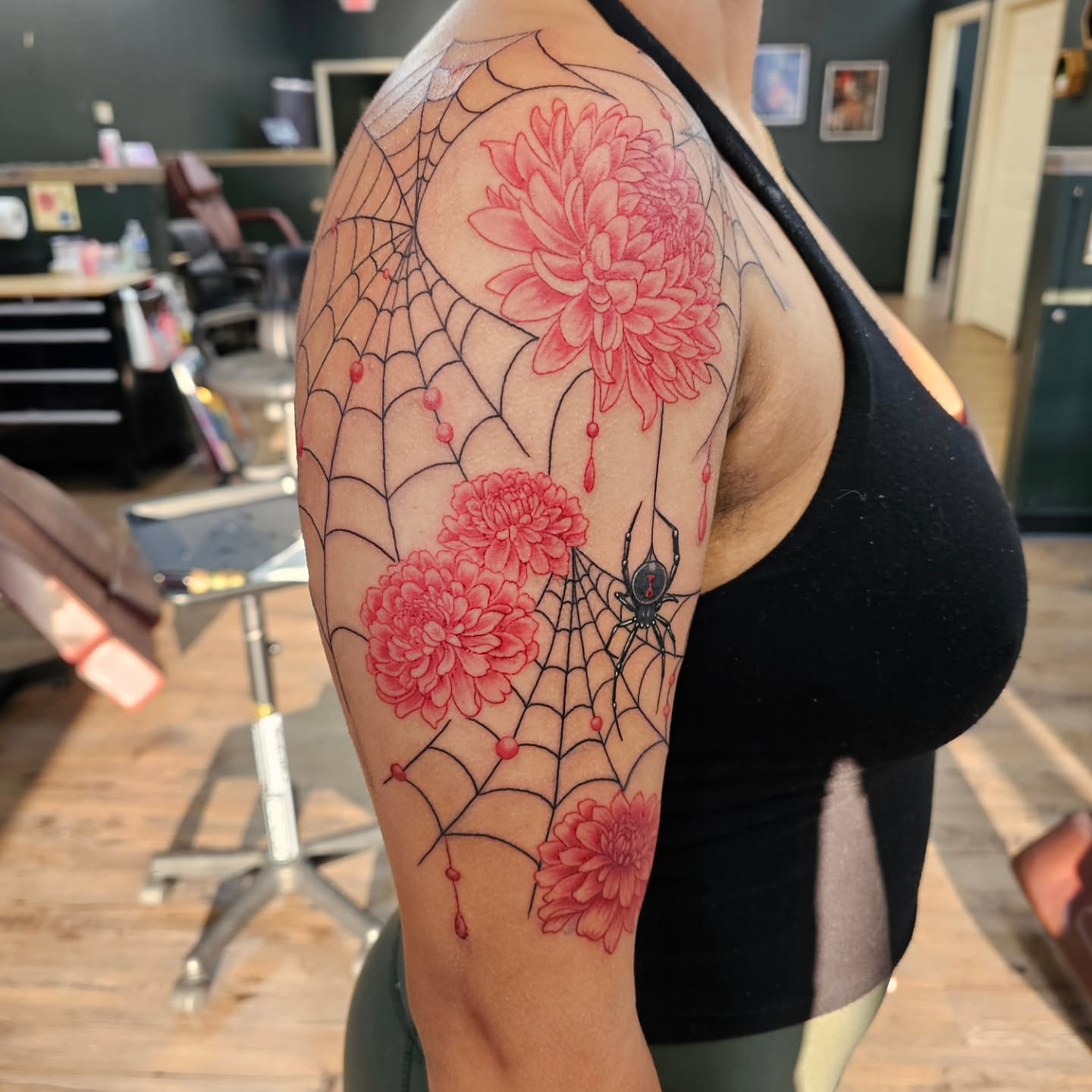 Spiderweb with flowers dotwork tattoo on the upper arm by Derek Davis