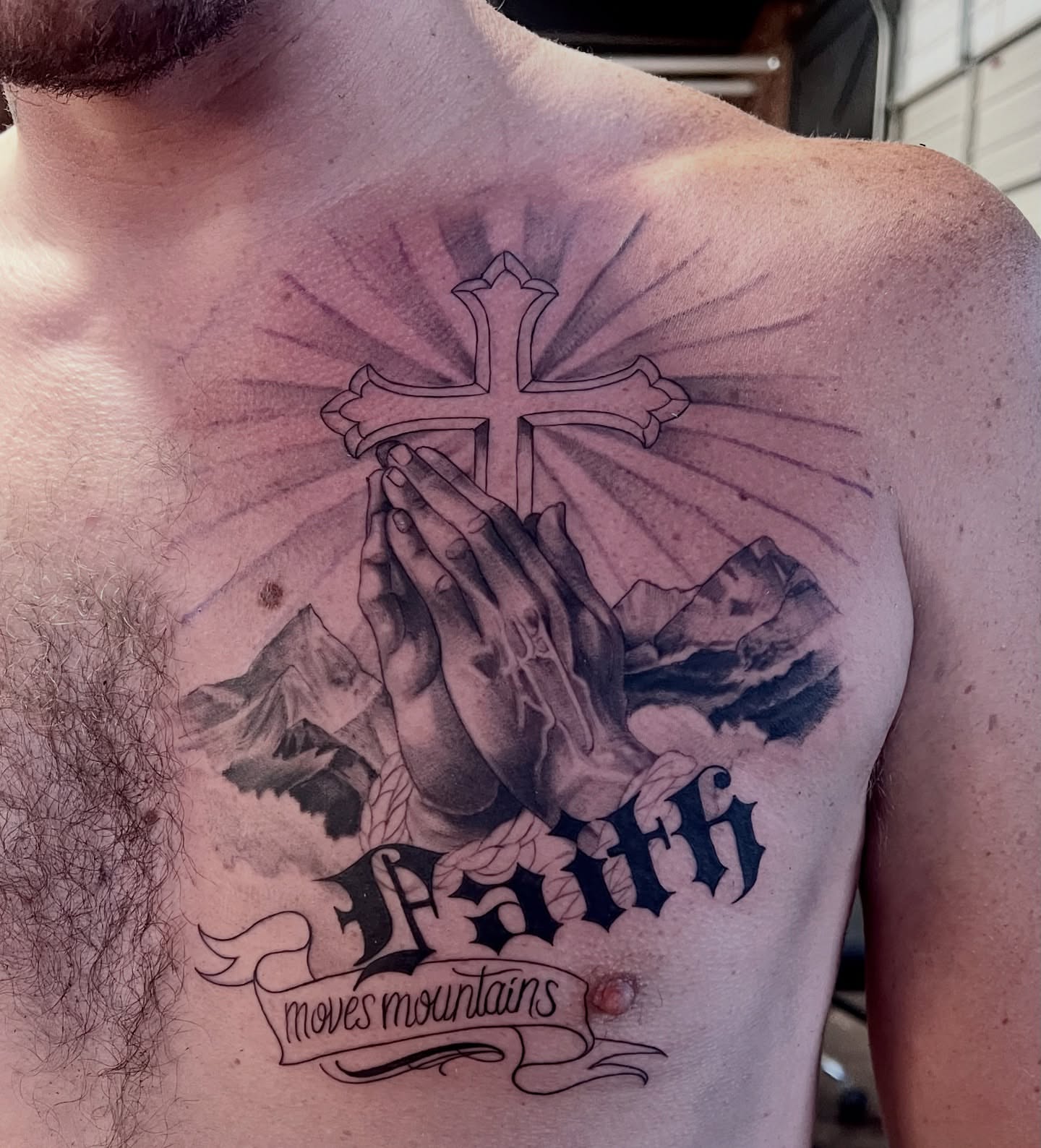 Praying hands with cross realism tattoo on the chest by Joi Bailey, Denton, Texas