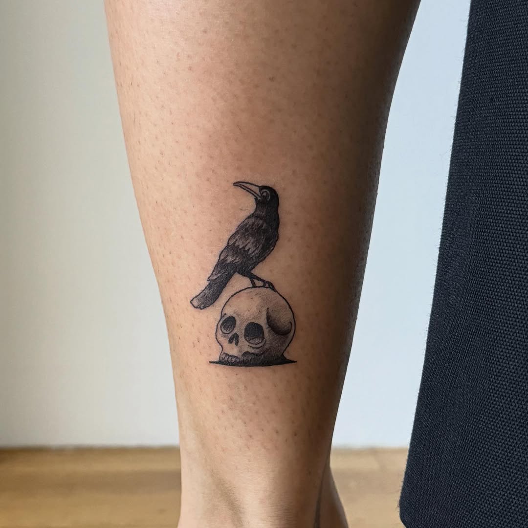 Crow on skull dark art tattoo on the calf by Kirsten
