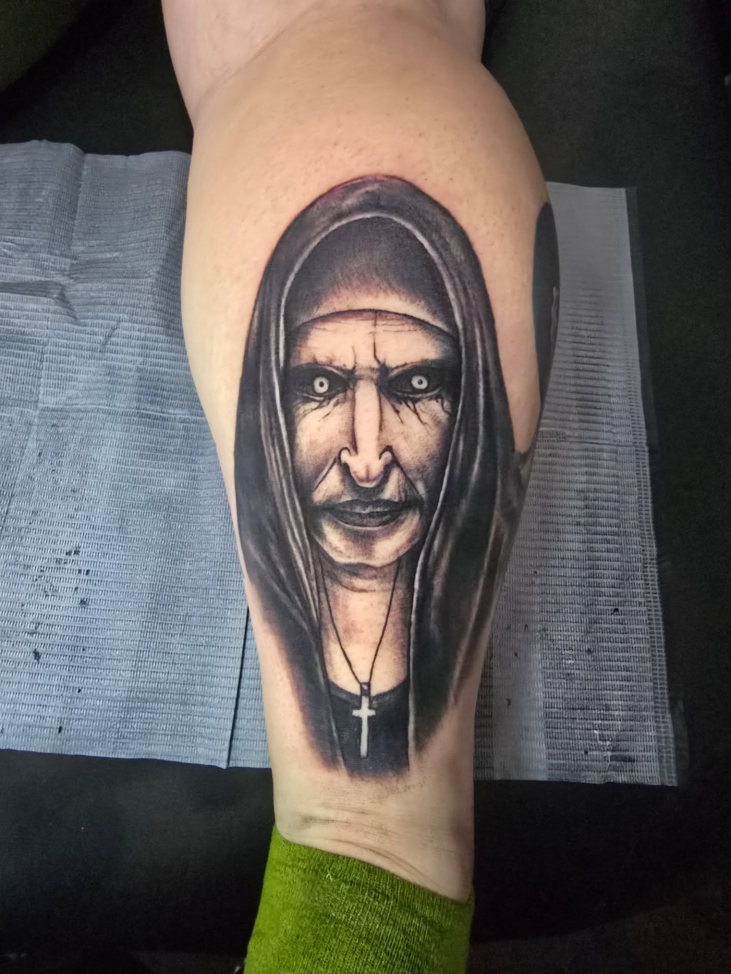 Hooded figure realism tattoo on the thigh by Tivis Phillips
