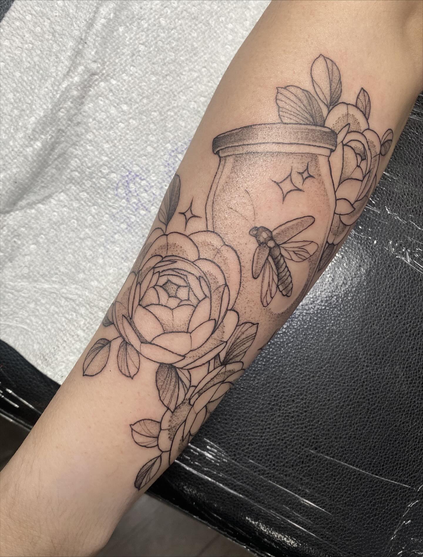 Jar with flowers and dragonfly black and grey tattoo on the forearm by K A R L y K I T S O N