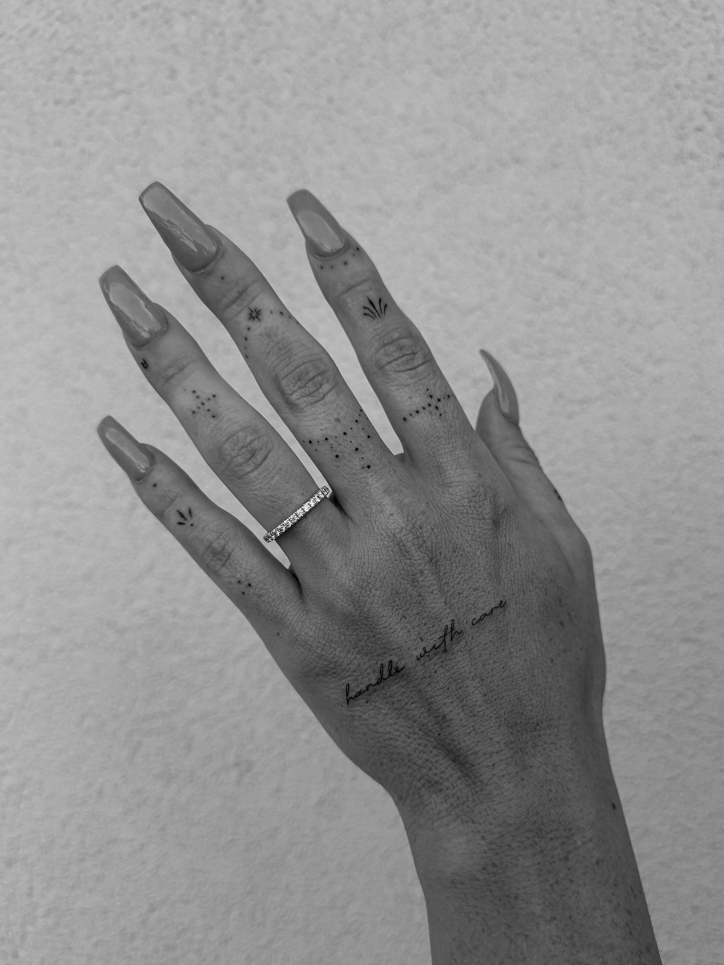 Dots and leaves dotwork tattoo on the hand by Abby Robinson