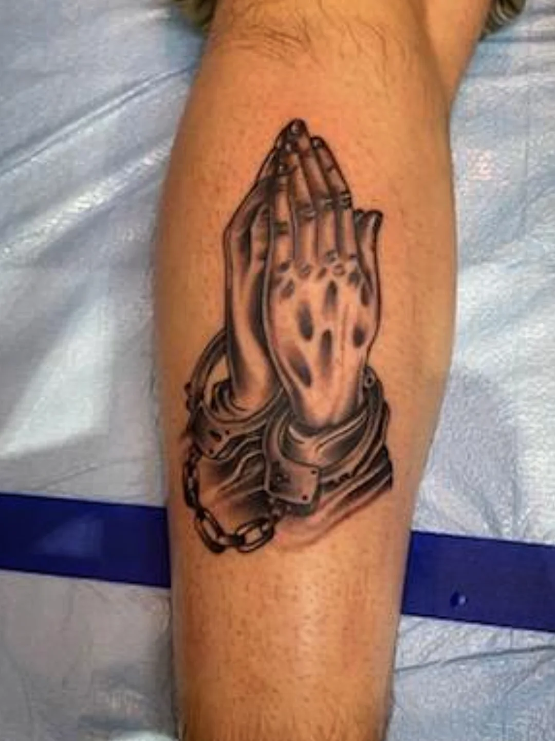 Praying hands realism tattoo on the forearm by Josh Sroga