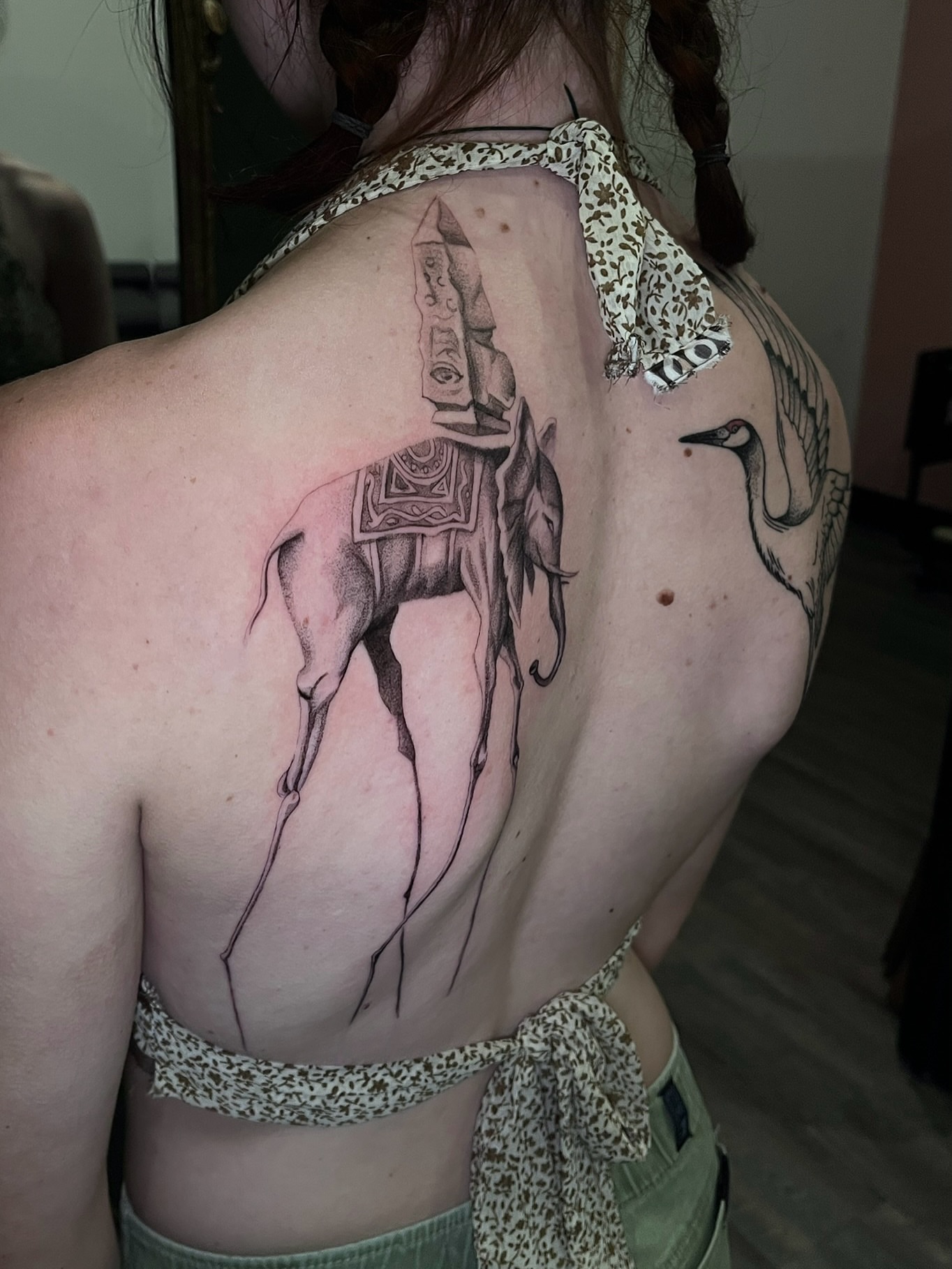 Camel and crane black and grey tattoo on the back by Samantha