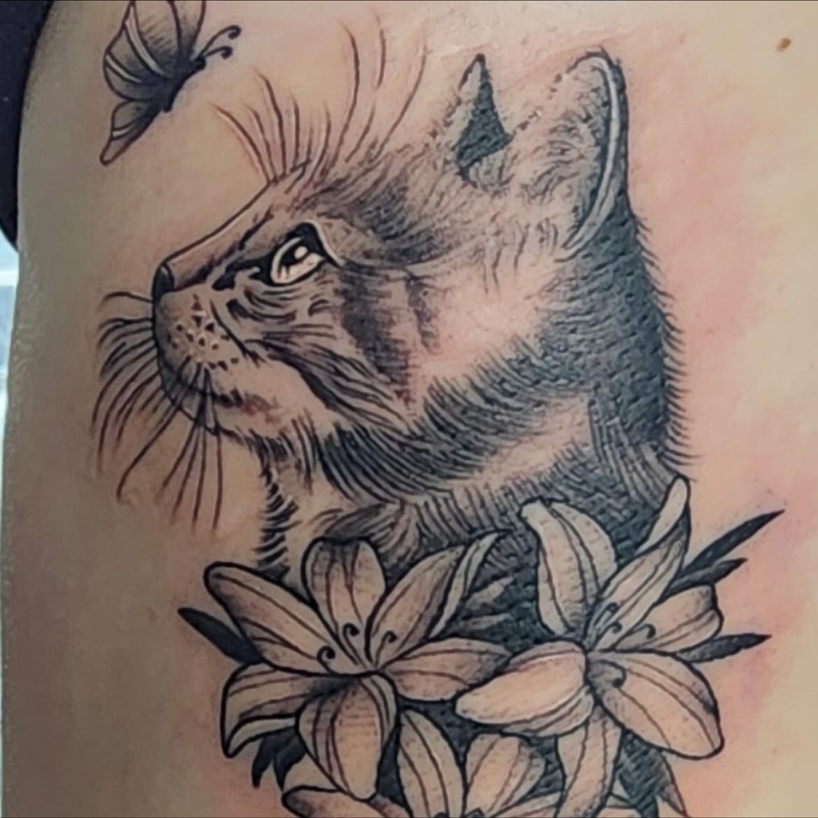 Cat and flowers realism tattoo on the thigh by Vyvyn Lazonga