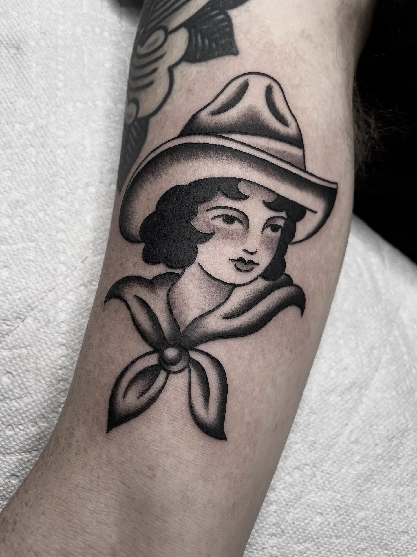 Woman wearing hat American traditional tattoo on the forearm by Kat, Sacramento, California