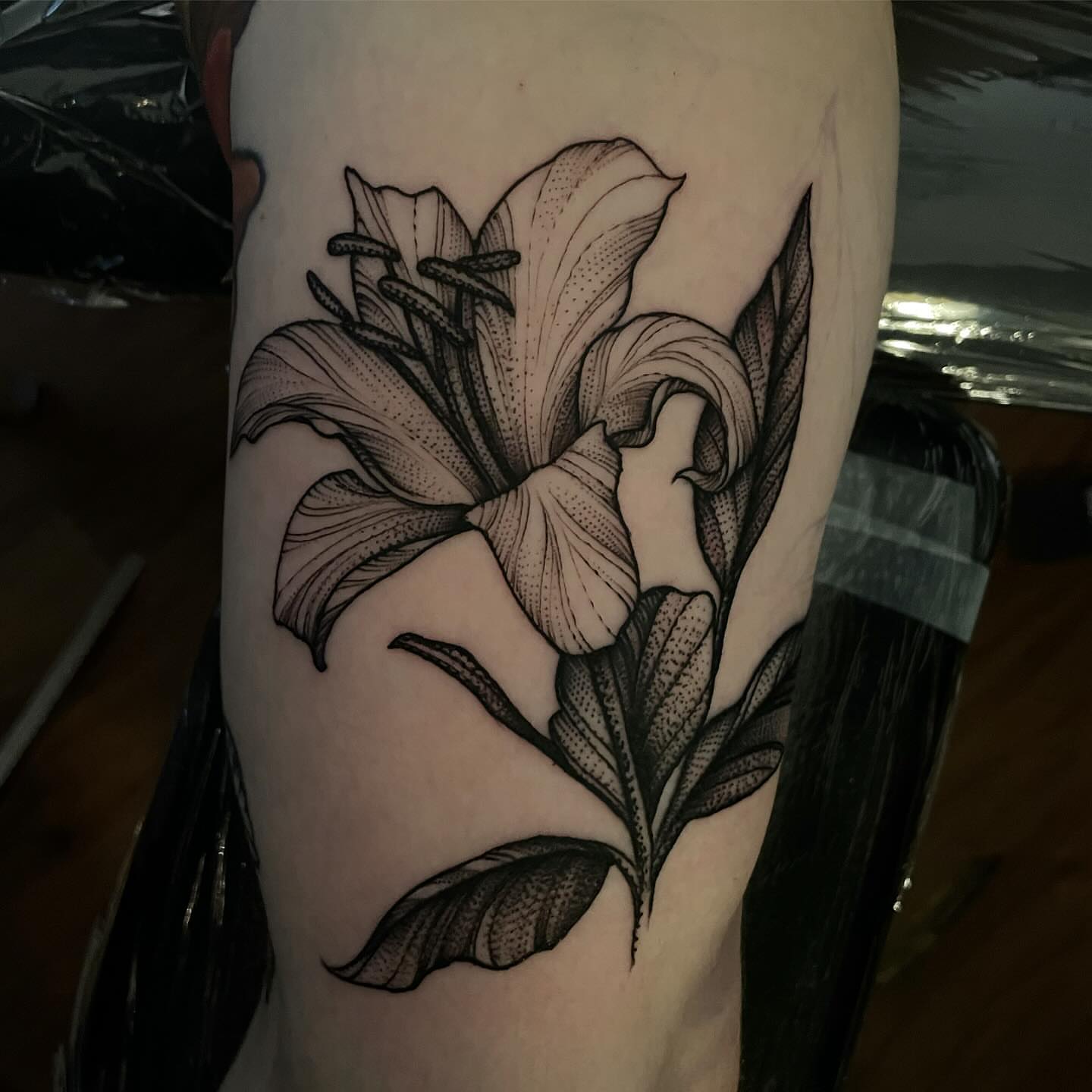 Lily dotwork tattoo on the forearm by Jacob Kearney