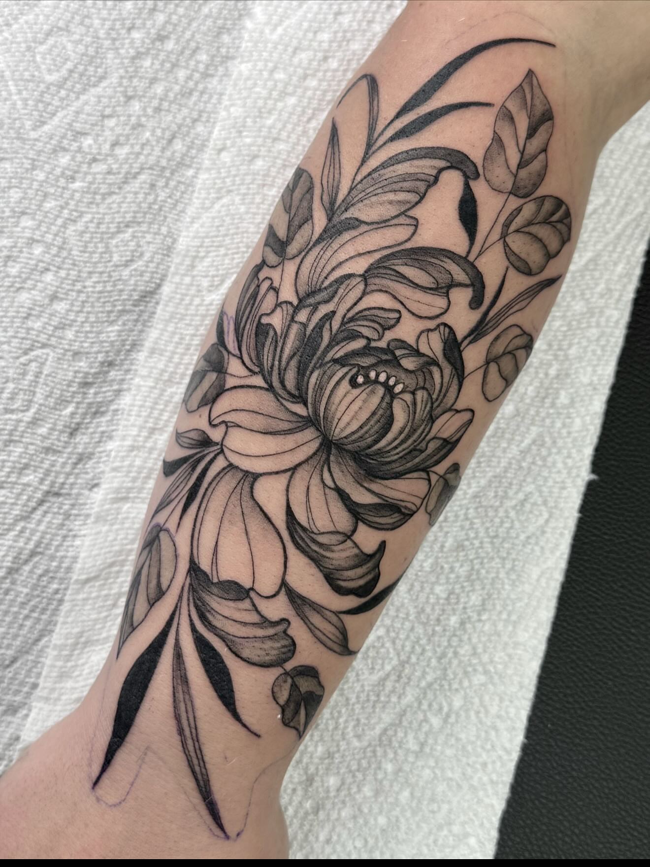Floral design black and grey tattoo on the forearm by Emmy