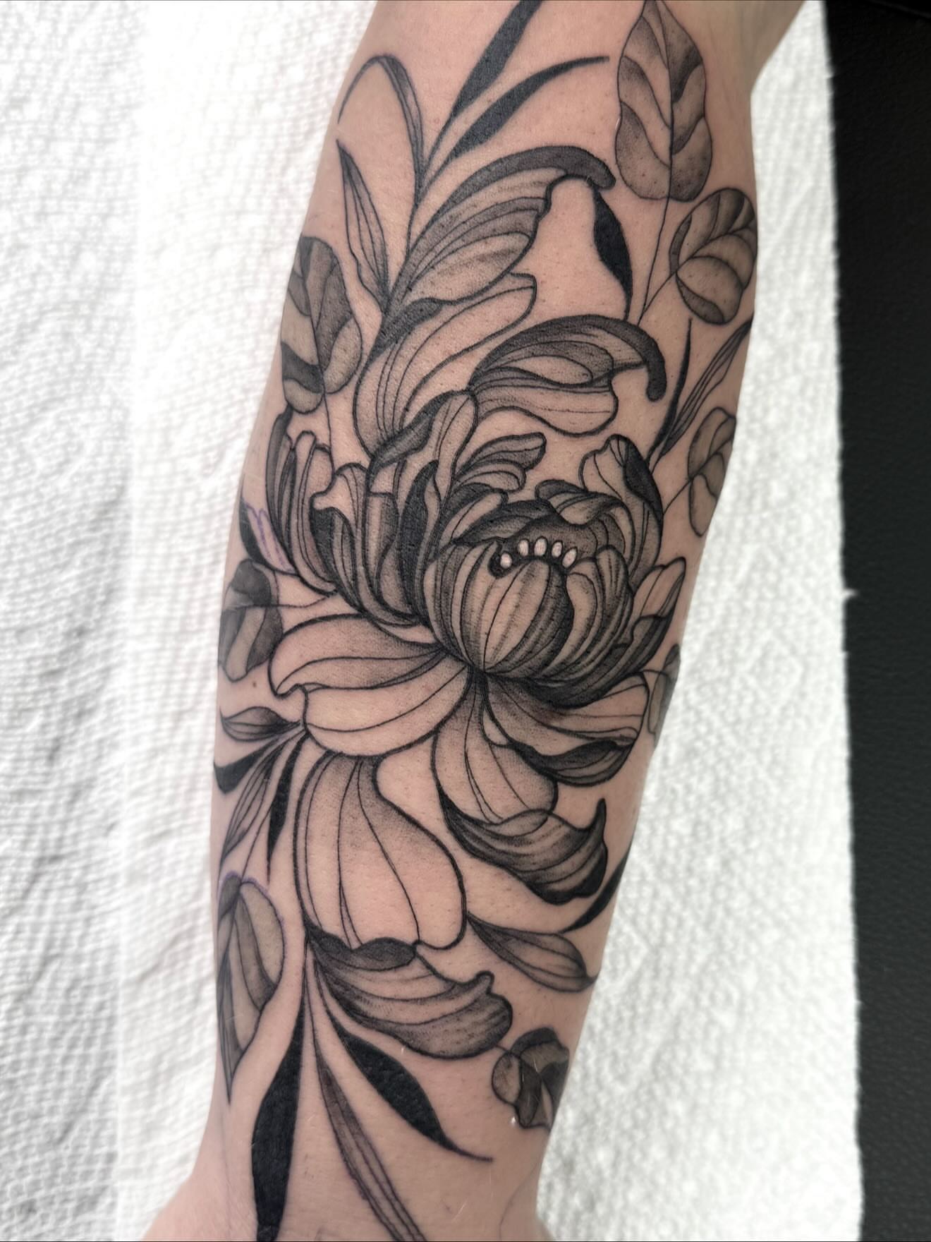 Flower black and grey tattoo on the forearm by Emmy