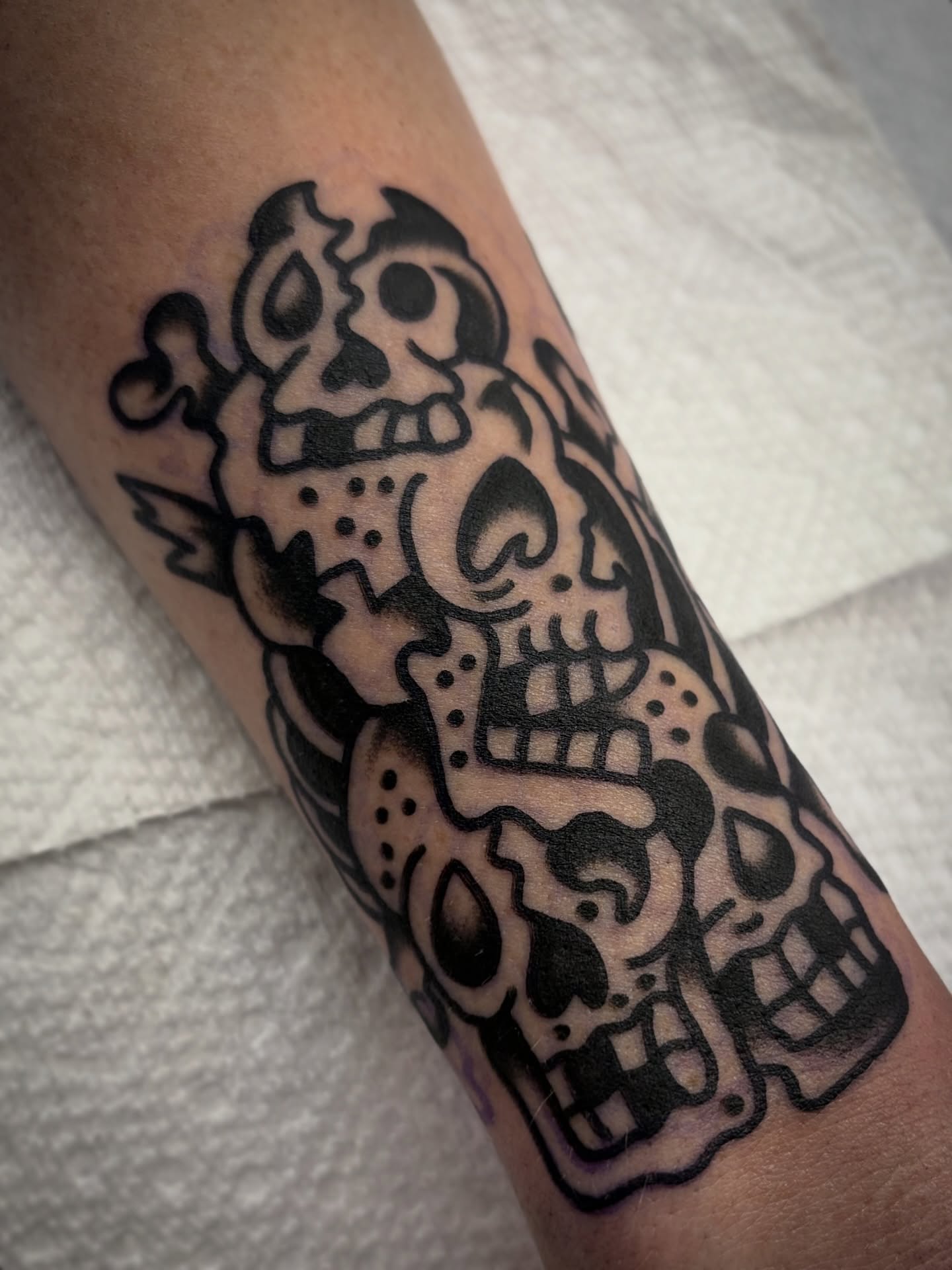 Skulls Chicano tattoo on the forearm by Carlos Gonzalez Tattoo, Dallas, Texas