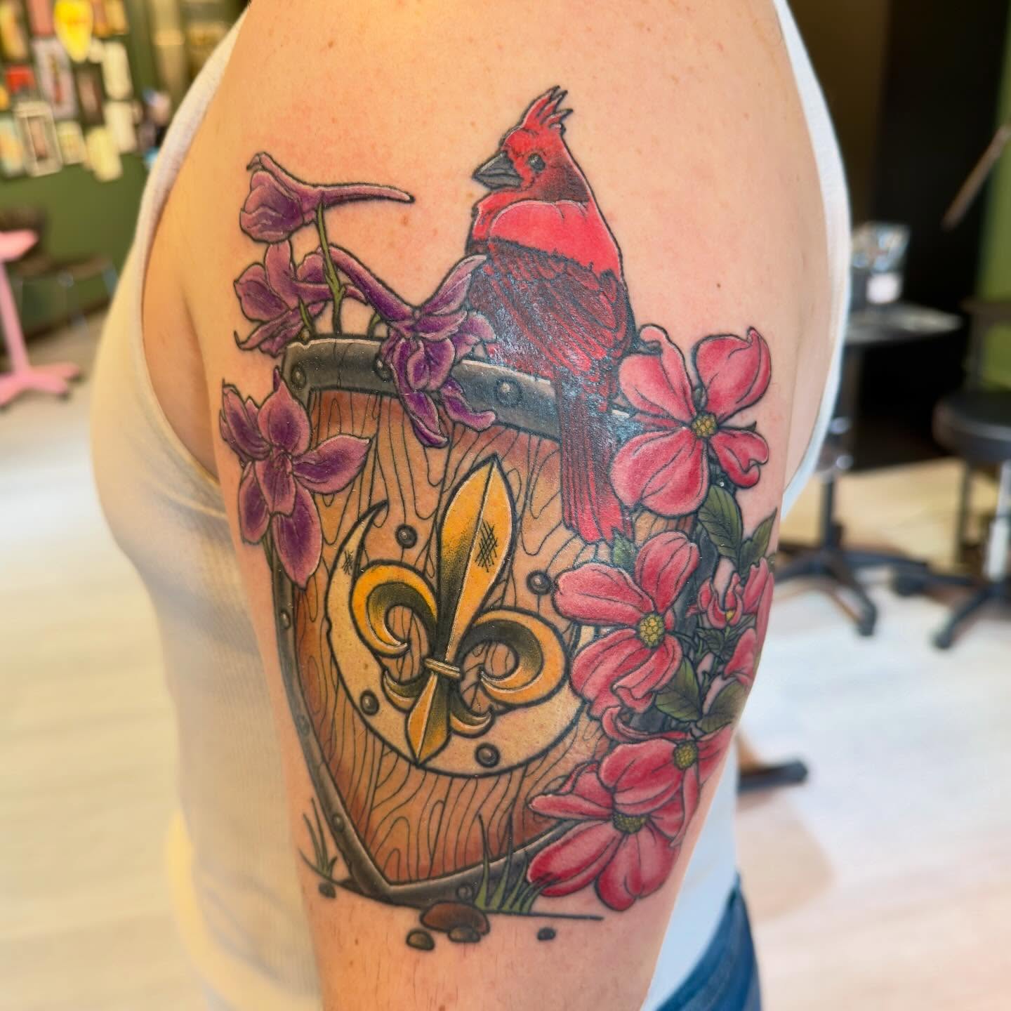 Cardinal and flowers realism tattoo on the upper arm by Patrick Carroll