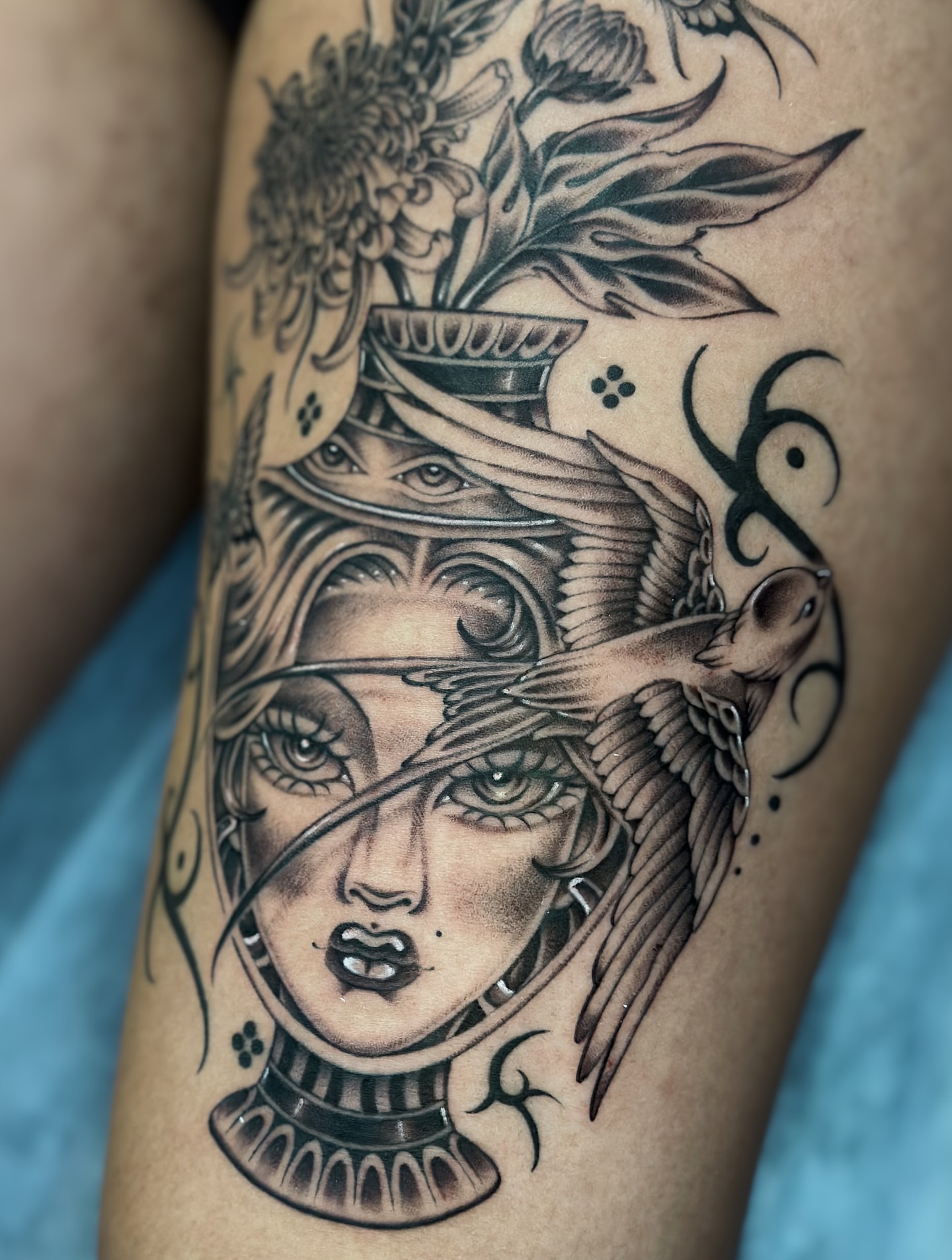 Woman's face with bird wings realism tattoo on the thigh by Lauryn Jenesis