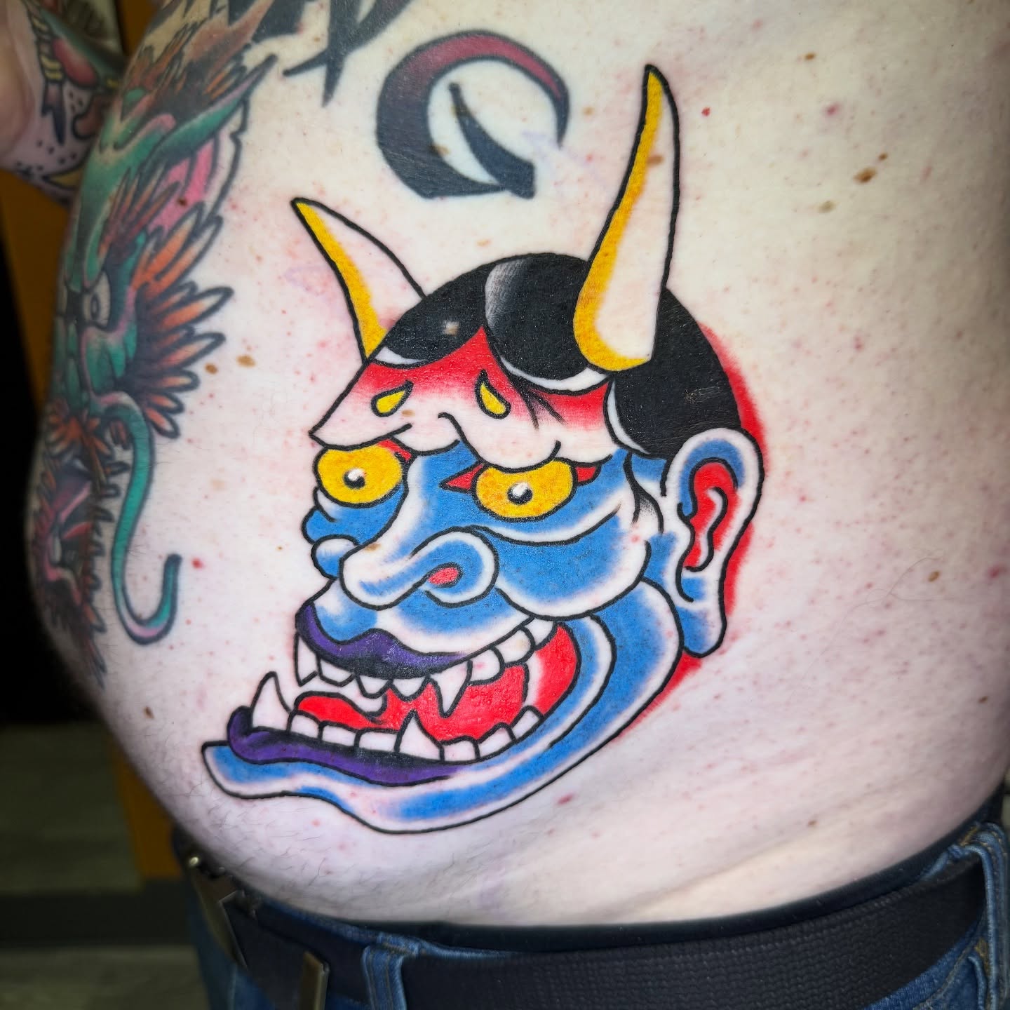 Demon mask American traditional tattoo on the torso by Mike Dunn