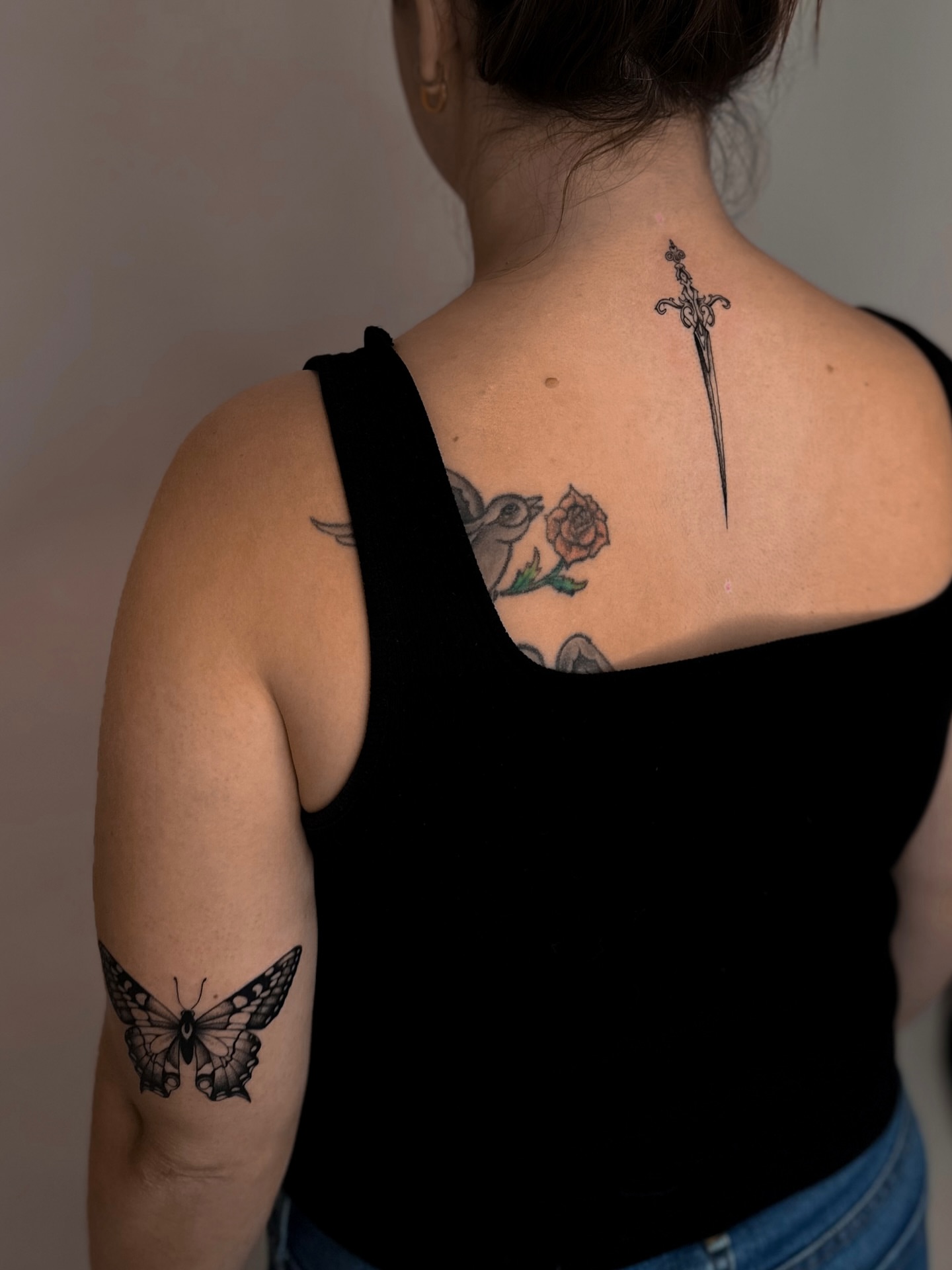 Bird, rose, sword black and grey tattoo on the back by Lauren