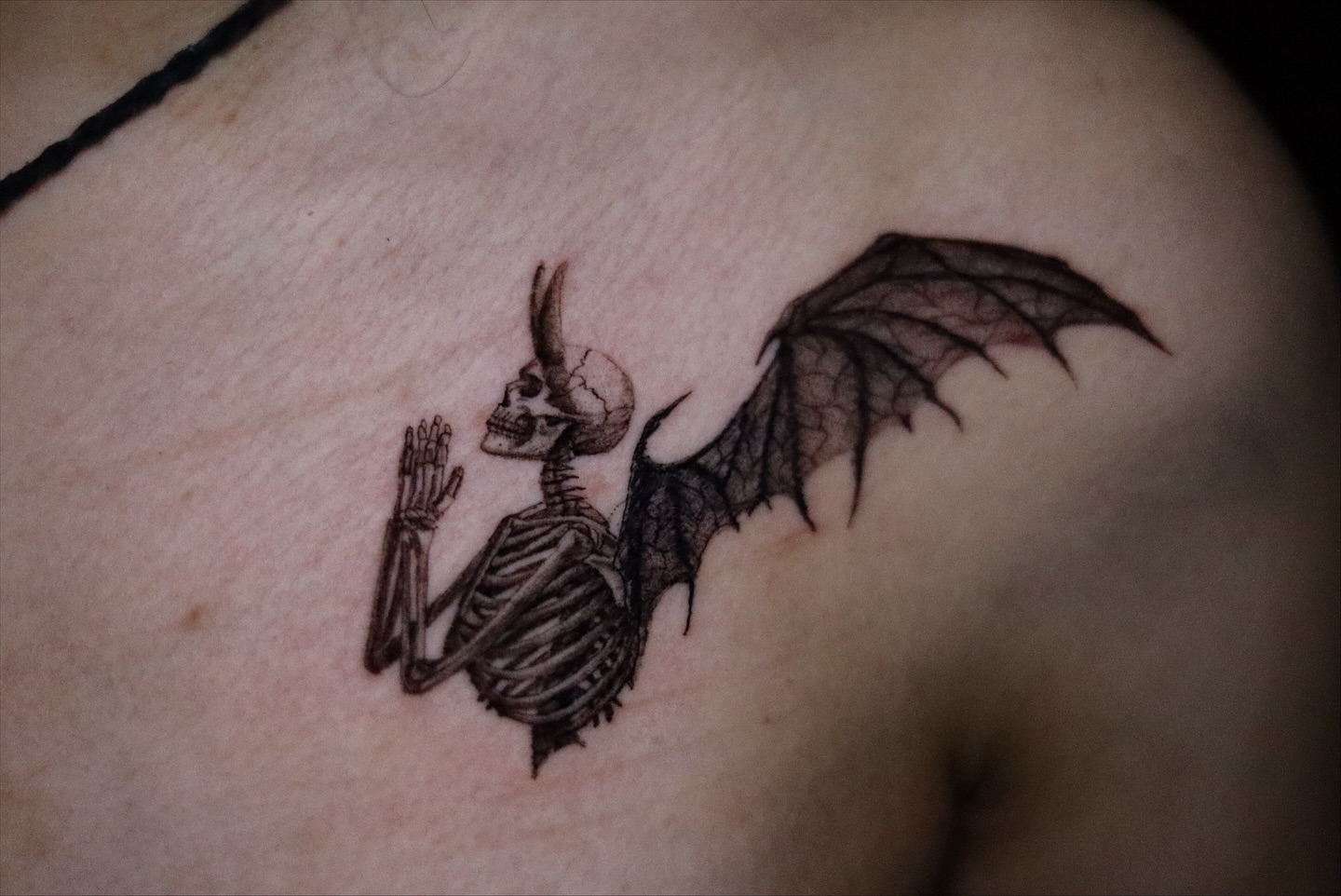 Skeleton with wings black and grey tattoo on the shoulder by Neeko
