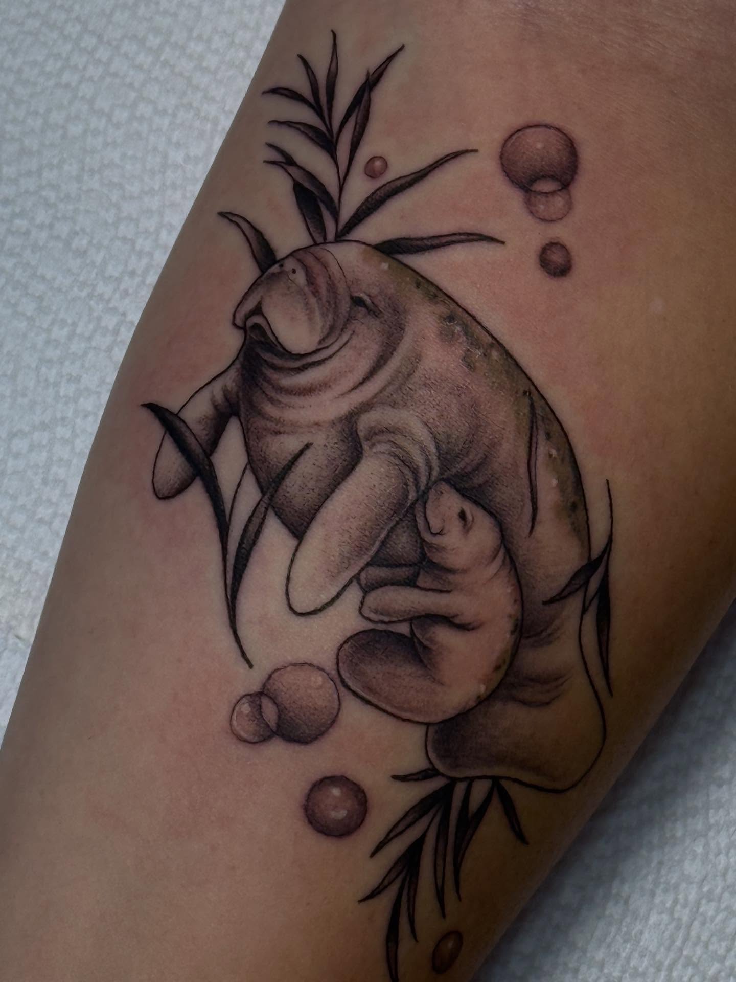 Manatee and calf realism tattoo on the forearm by Espinal