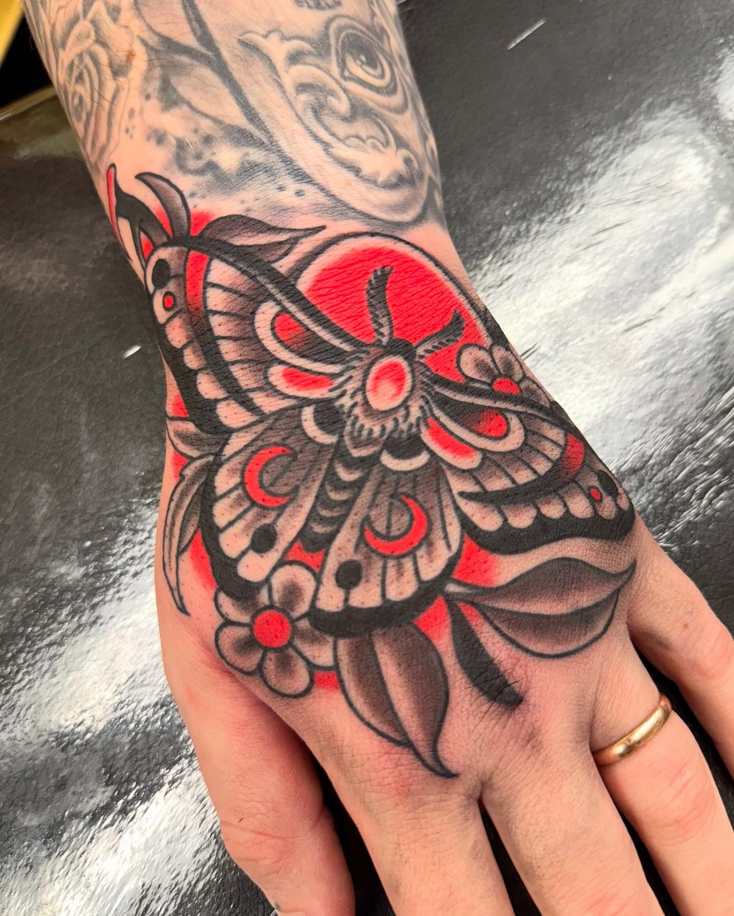 Butterfly American traditional tattoo on the hand by Ethan Bennett